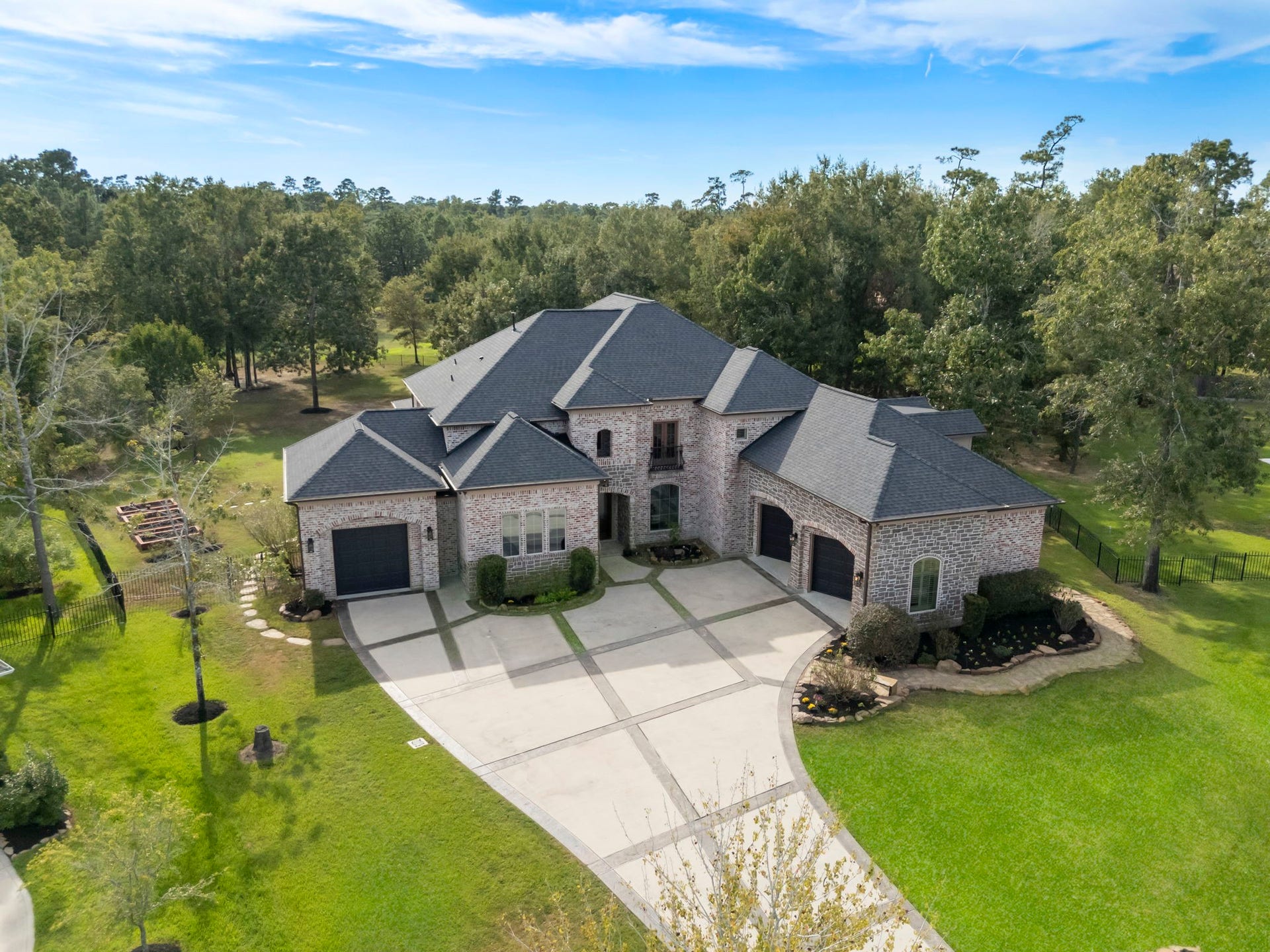 27507 Hunter Creek Court, Spring, TX 77386 Elevated aerial view showing the home's roofline, driveway configuration and wooded lot.