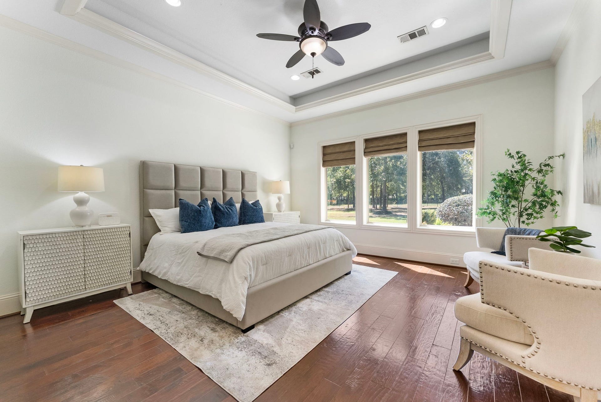 27507 Hunter Creek Court, Spring, TX 77386 Primary bedroom with hardwood flooring, tray ceiling, recessed lighting and large windows overlooking the grounds.