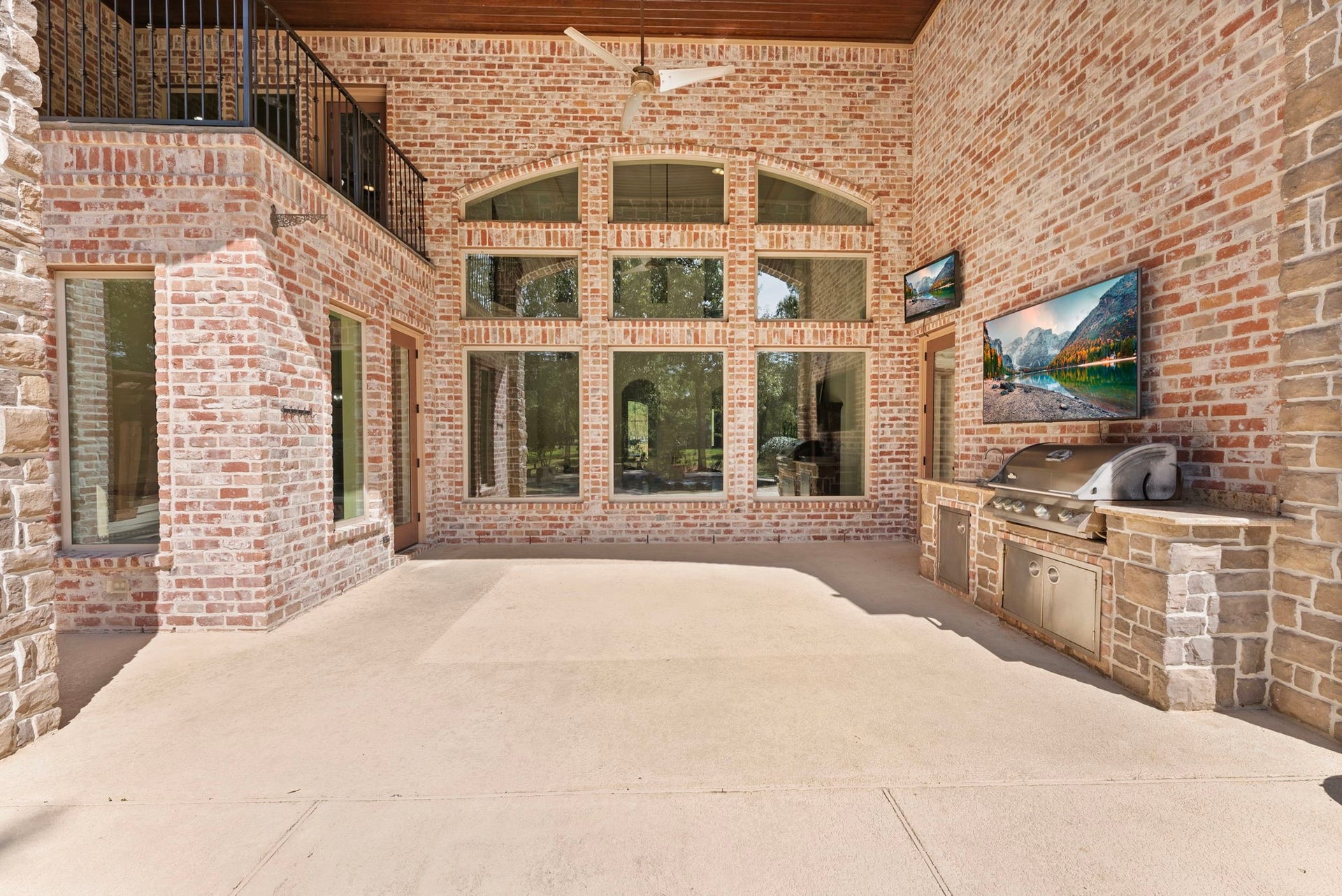 27507 Hunter Creek Court, Spring, TX 77386 Covered outdoor living area with tall brick walls, built-in outdoor kitchen and views toward the pool.