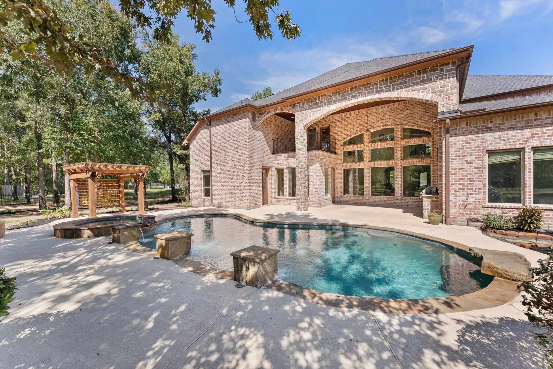 27507 Hunter Creek Court, Spring, TX 77386 Poolside view highlighting the rear elevation, two-story covered patio and pergola.