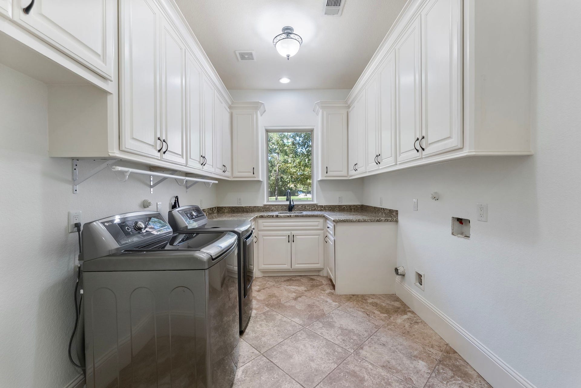 27507 Hunter Creek Court, Spring, TX 77386 Utility room with abundant cabinetry, granite counter space and natural light.