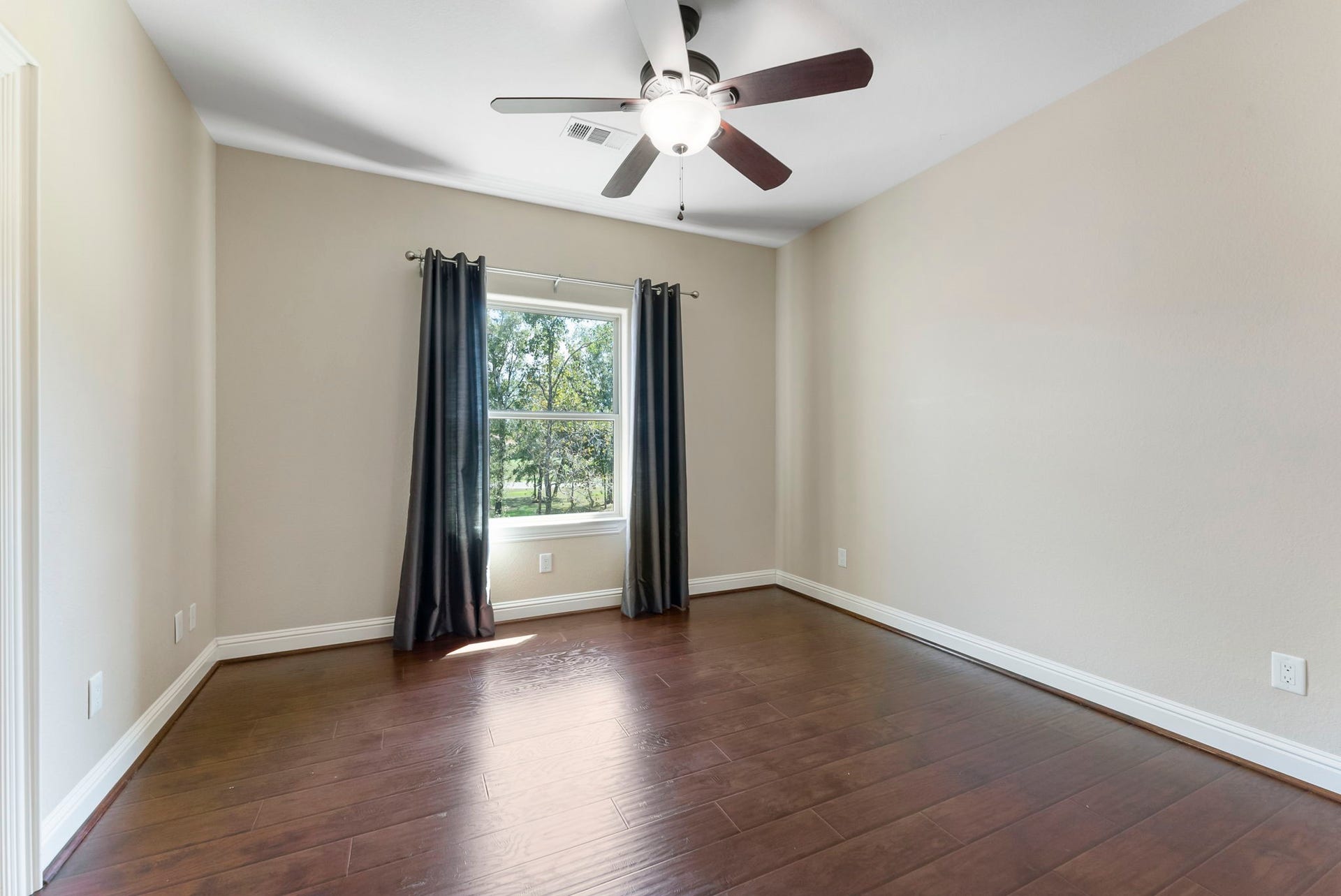 27507 Hunter Creek Court, Spring, TX 77386 Secondary bedroom with hardwood flooring, ceiling fan and natural light.