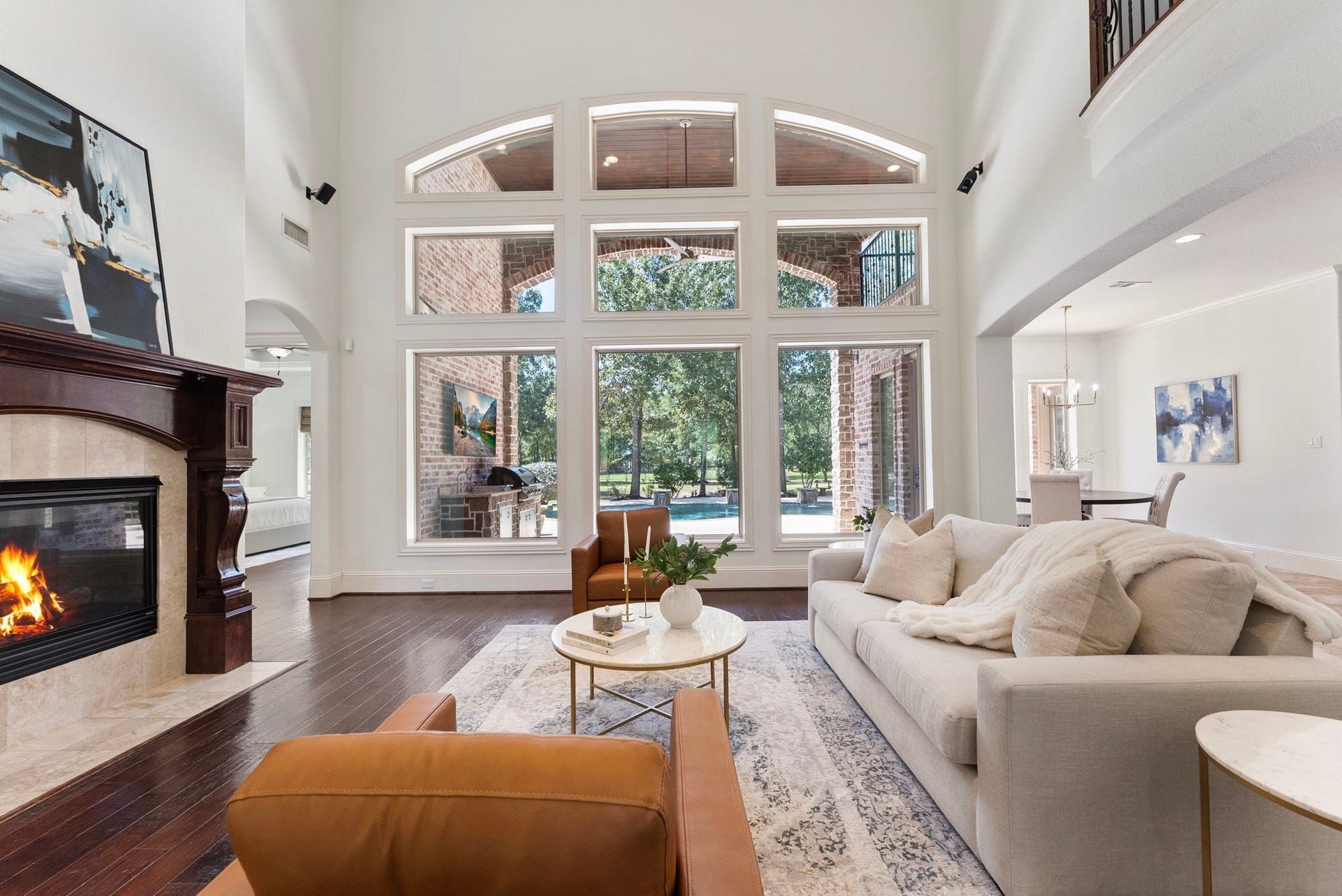 27507 Hunter Creek Court, Spring, TX 77386 Living room with soaring ceiling, fireplace and an impressive wall of windows overlooking the backyard.