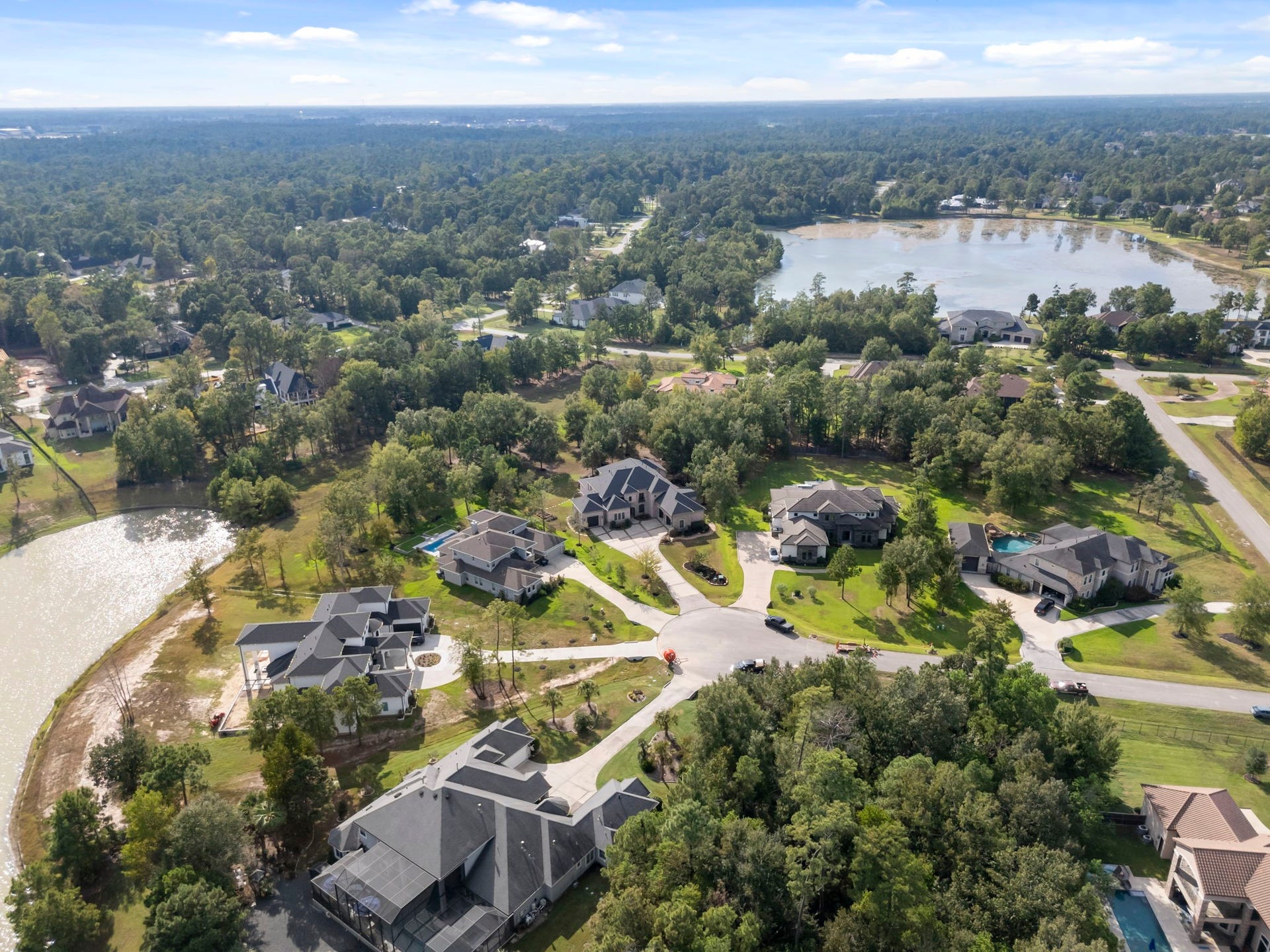 27507 Hunter Creek Court, Spring, TX 77386 Wide aerial overview showing the property's wooded neighborhood setting and surrounding water features.