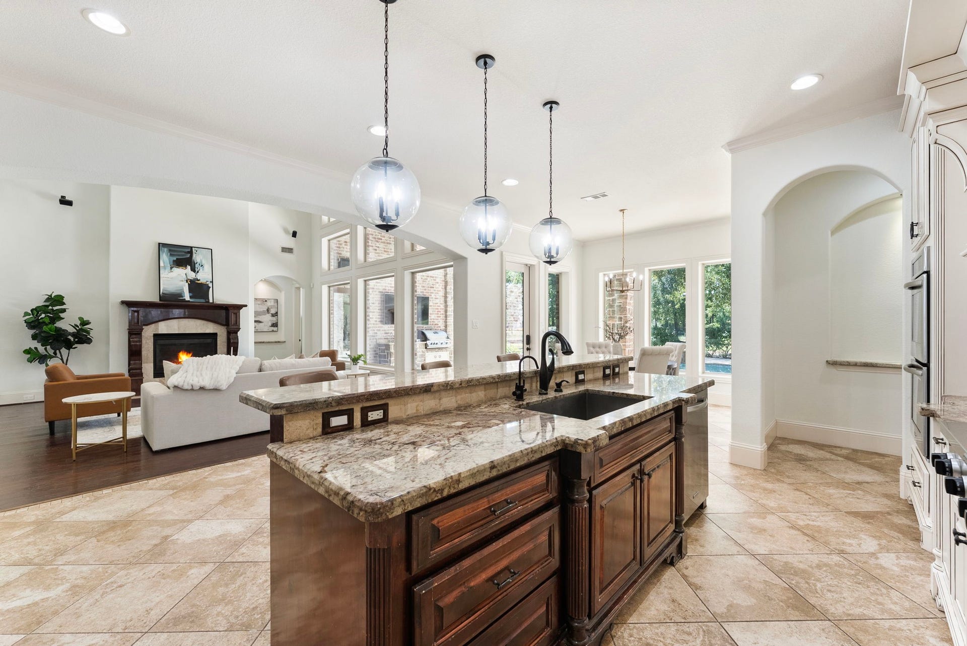 27507 Hunter Creek Court, Spring, TX 77386 Kitchen island with granite surfaces and open views into the living room and outdoor areas.