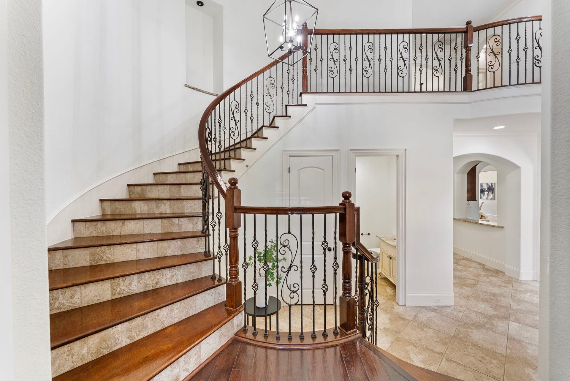 27507 Hunter Creek Court, Spring, TX 77386 Curved staircase featuring wood treads and decorative wrought-iron railing.