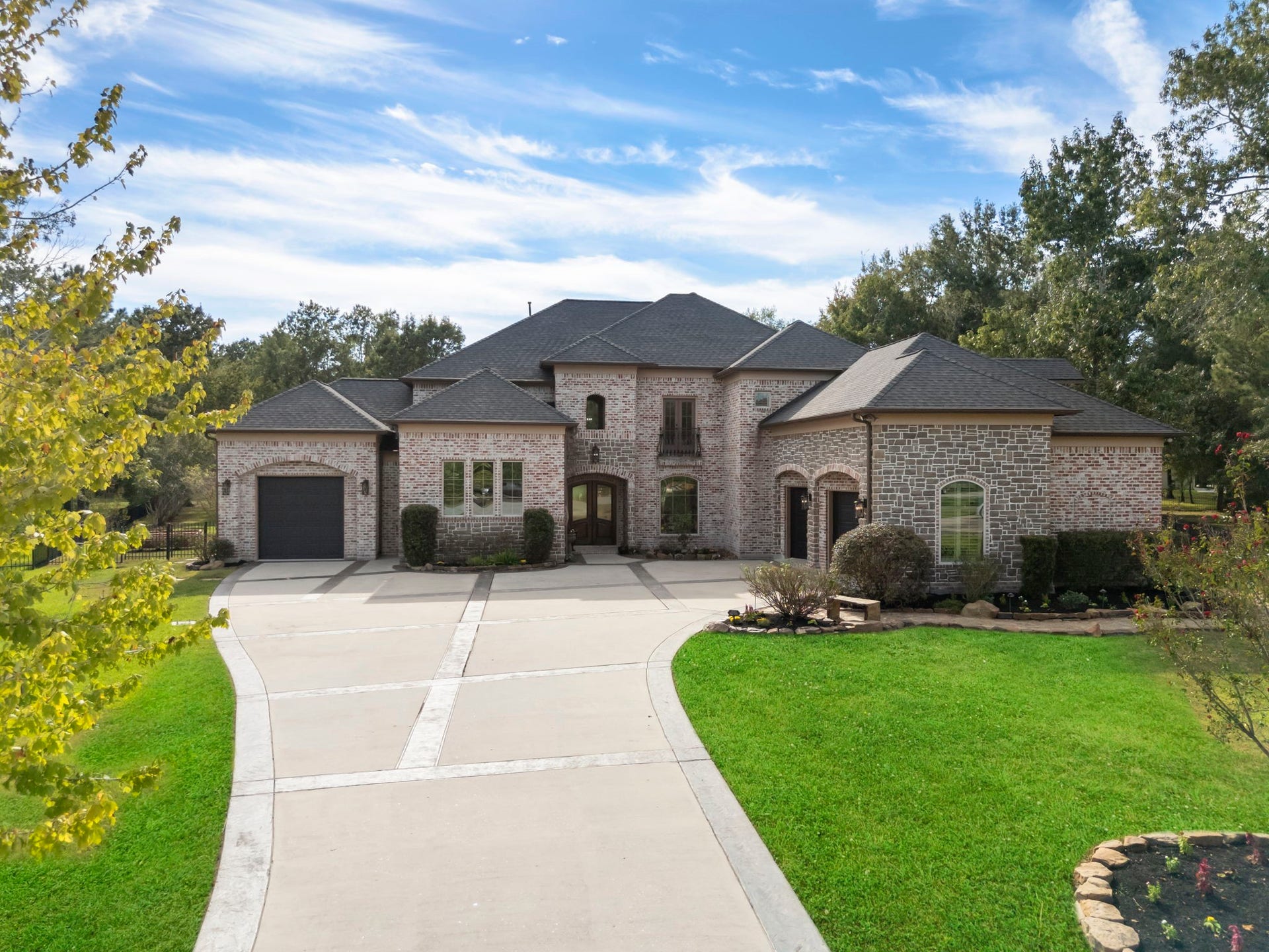 27507 Hunter Creek Court, Spring, TX 77386 Low aerial view highlighting the home's front architecture, curved driveway and landscaped grounds.