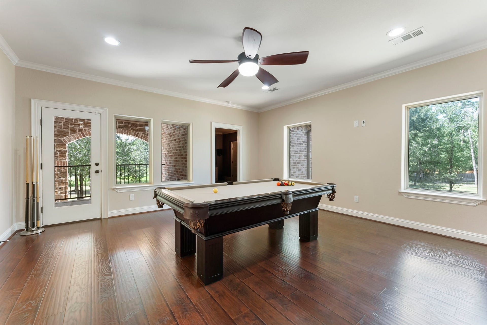27507 Hunter Creek Court, Spring, TX 77386 Upstairs game room with hardwood flooring, ceiling fan, multiple windows and access to the balcony.