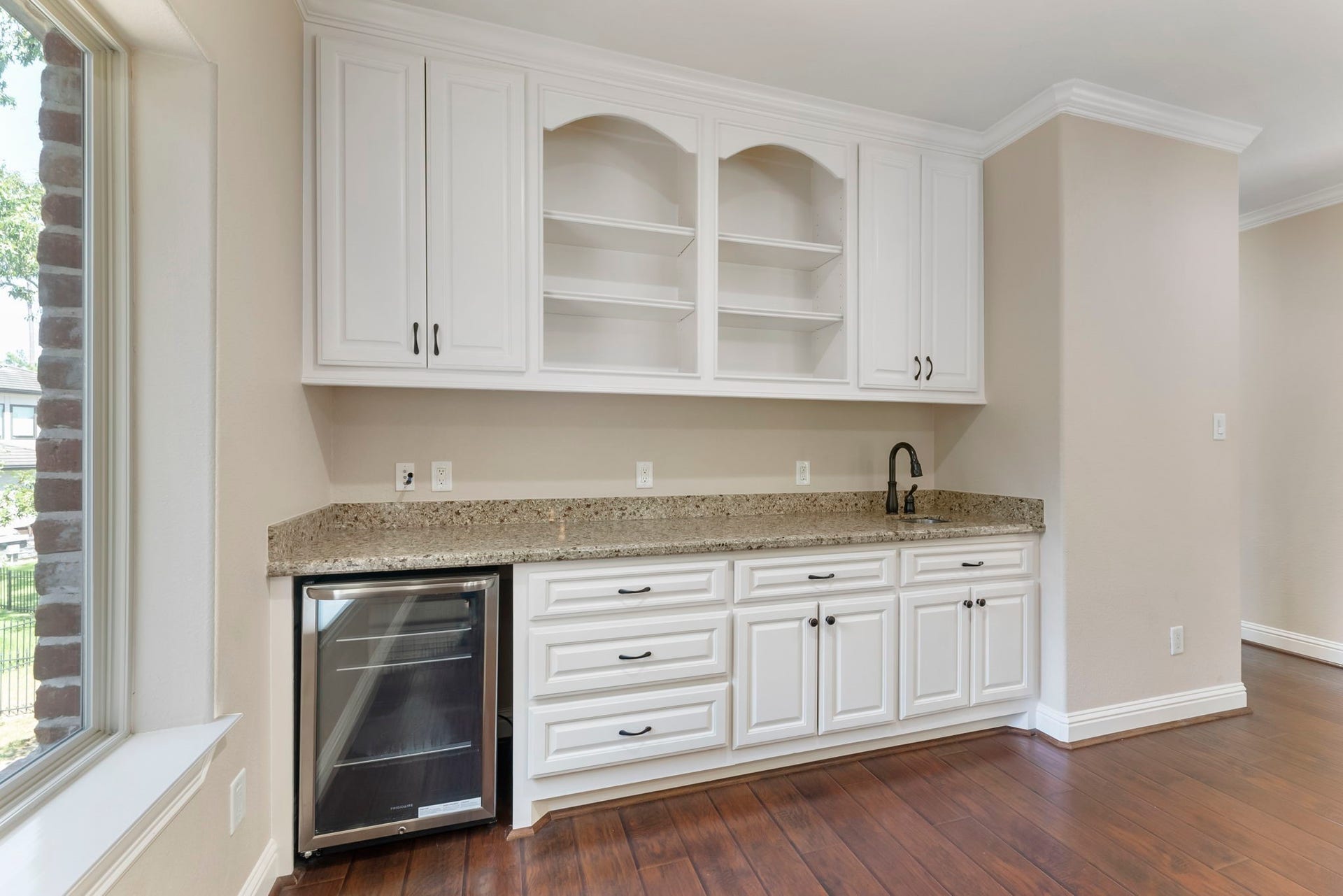 27507 Hunter Creek Court, Spring, TX 77386 Game-room wet bar with granite countertop, built-in cabinetry, shelving and beverage refrigerator.