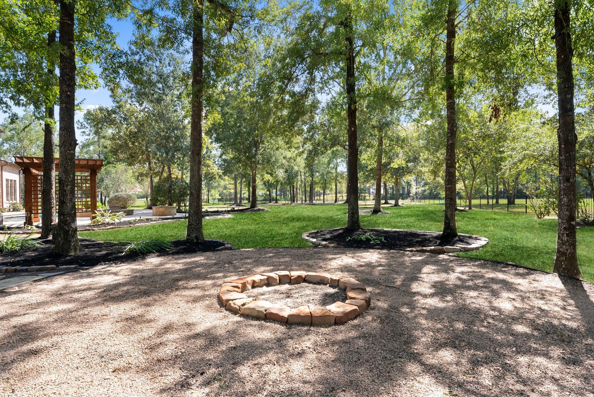27507 Hunter Creek Court, Spring, TX 77386 Wooded portion of the backyard featuring a dedicated stone fire-pit area.