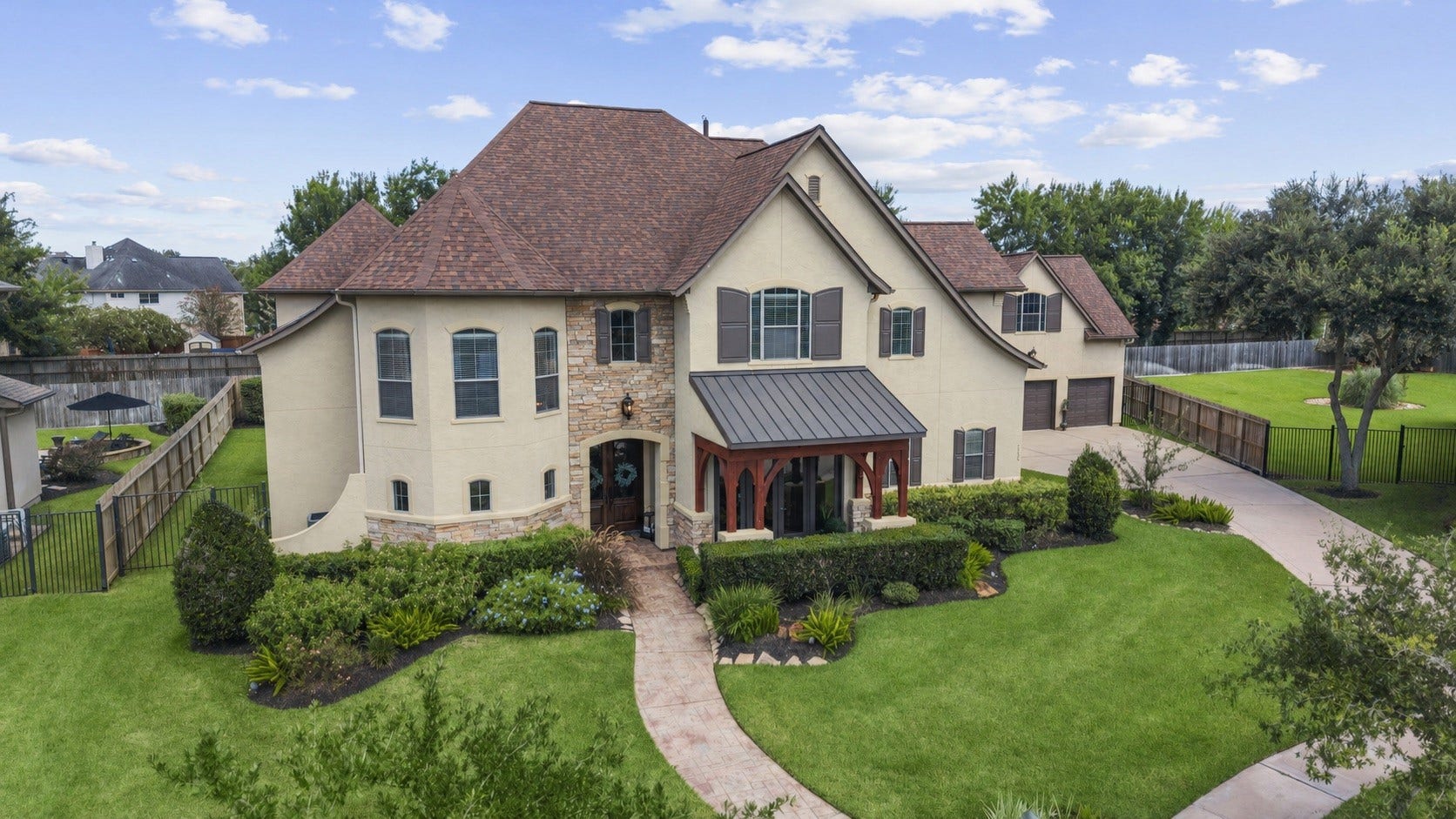 Stunning front elevation with manicured landscaping and a spacious three car garage.