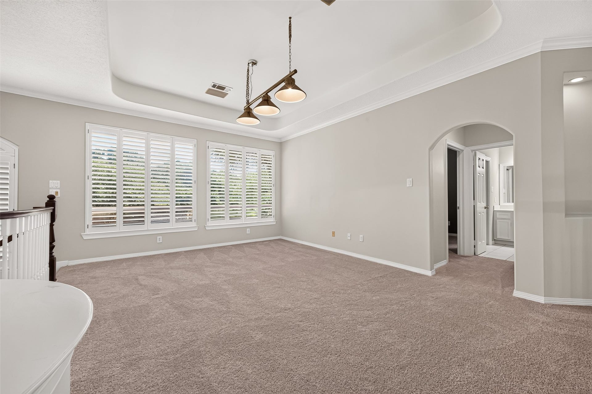 63 Harbor View Drive, Sugar Land, TX 77479 Spacious and bright game room area off the stairs landing. Notice the large windows with beautiful plantation shutters, elegant tray ceiling, and plush carpeting.
