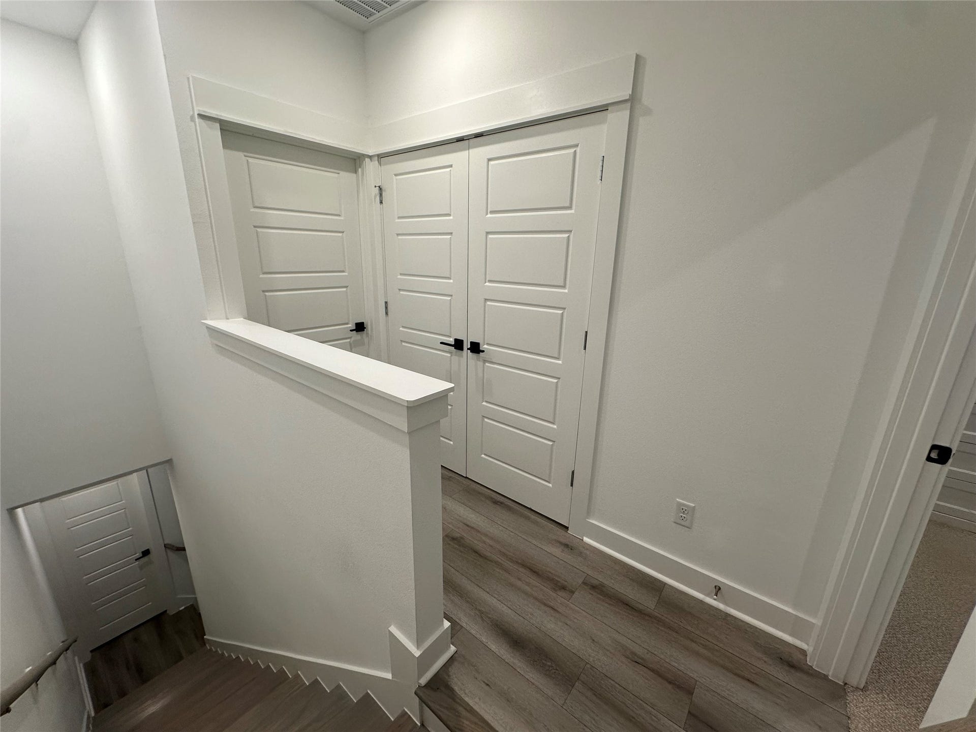 Third-floor hallway with convenient access to the primary suite, laundry room, and an additional bedroom.