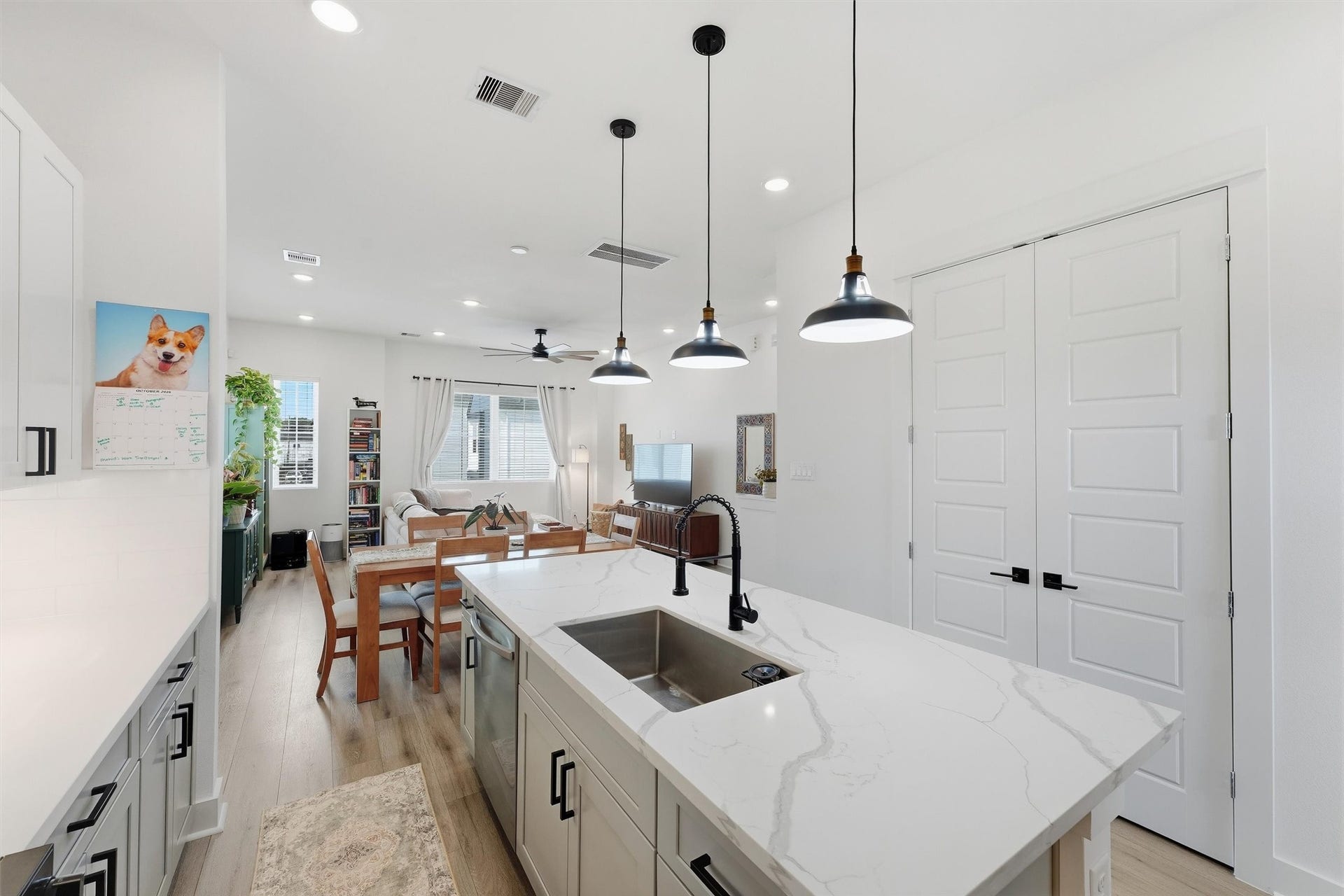 Open-concept layout with a double-door pantry just off the island.