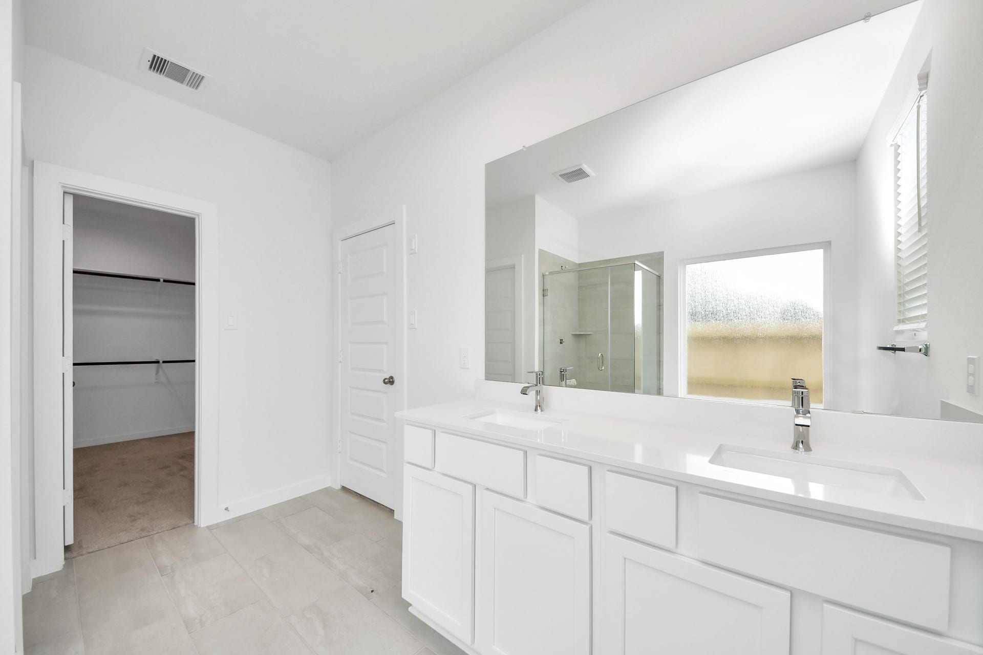 5814 Madison Trail Drive, Richmond, TX 77469 Elevate your daily routine at the elegant vanity, now equipped with double sinks, light countertops, modern hardware, and beautiful recessed lights. Sample photo of completed home with similar floor plan. Actual colors and selections may vary.
