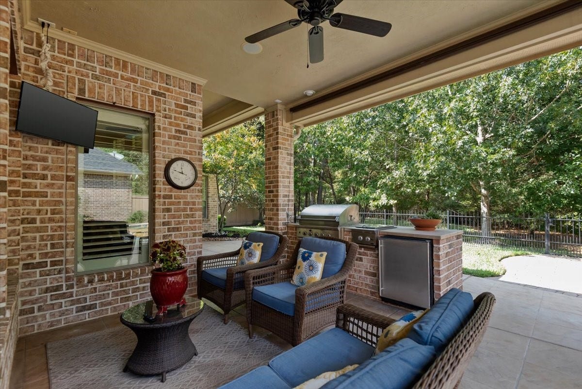 5530 Regal Landing Drive, Kingwood, TX 77345 Covered patio has a TV and grill, gas burner and fridge- perfect for backyard entertaining.