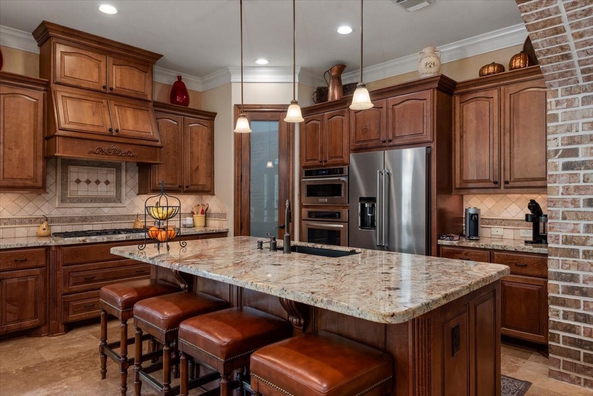 5530 Regal Landing Drive, Kingwood, TX 77345 The island adds extra seating for guests in the kitchen. Elegant pendant lighting illuminate the island workspace.