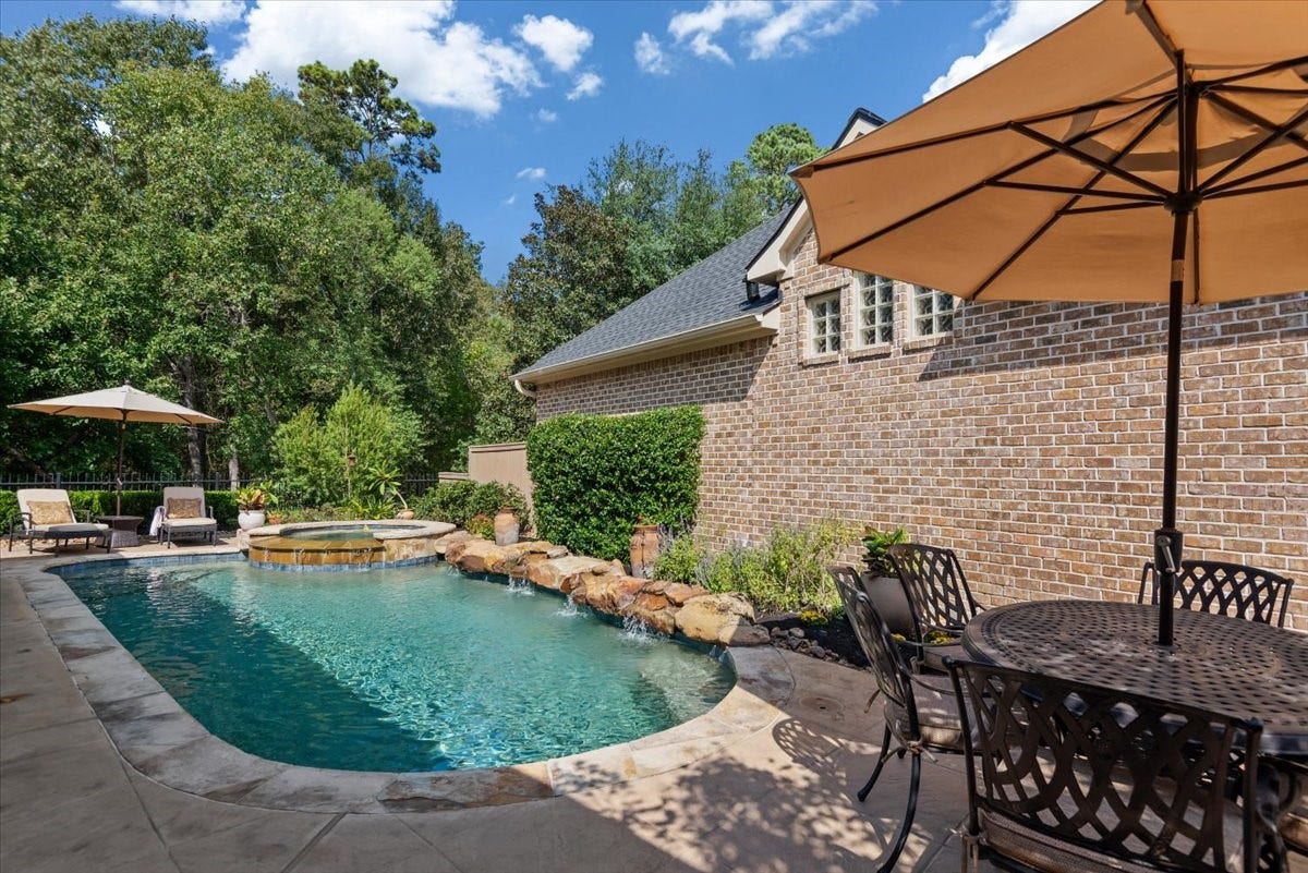 5530 Regal Landing Drive, Kingwood, TX 77345 Refreshing pool and spa features rock waterfalls, pebble tech finish, flagstone edge, and lush landscape.