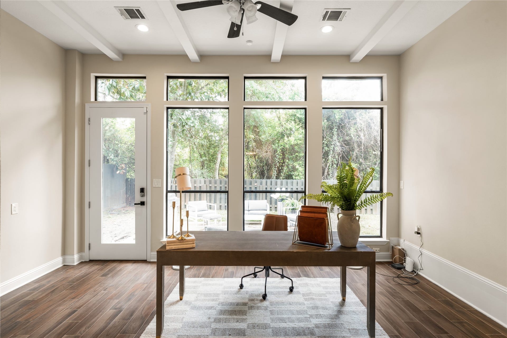4719 Breezy Point Drive, Houston, TX 77345 A light filled home office framed by an impressive wall of windows, offering serene backyard views and direct access to the outdoor living area and steps away from the breakfast area.