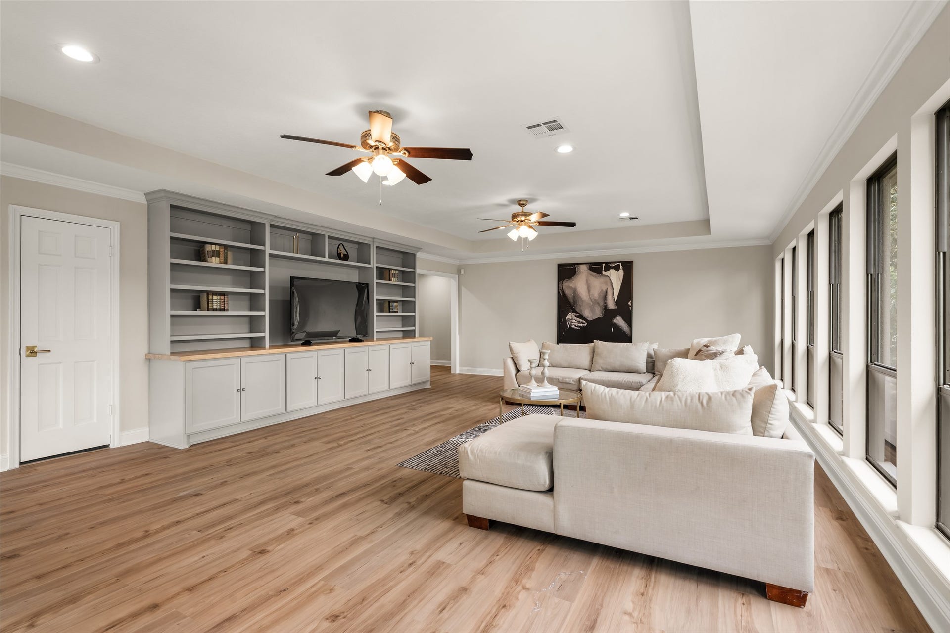 4719 Breezy Point Drive, Houston, TX 77345 Designed as an elevated second living space, the upstairs family room features a newer media center, cabinetry, and bookshelves complemented by abundant windows and generous room for gathering.