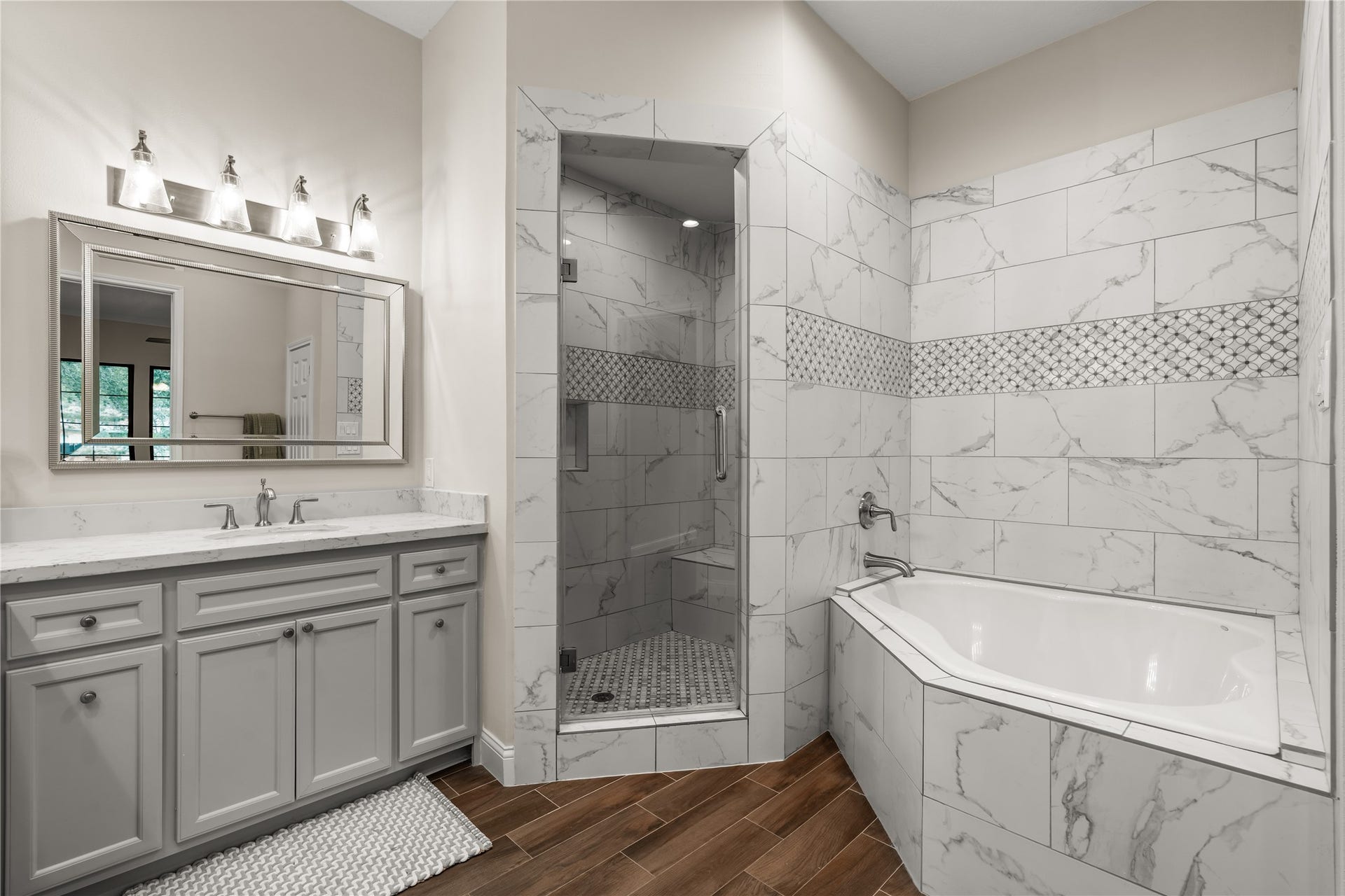 4719 Breezy Point Drive, Houston, TX 77345 A spa-inspired retreat complete with a soaking tub, separate glass-enclosed shower, and decorative tile work.