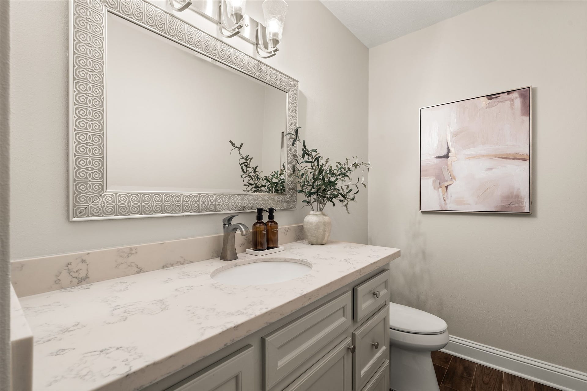 4719 Breezy Point Drive, Houston, TX 77345 A sophisticated powder bath pairs an extended vanity with elegant finishes and a statement mirror, creating a polished space for guests.