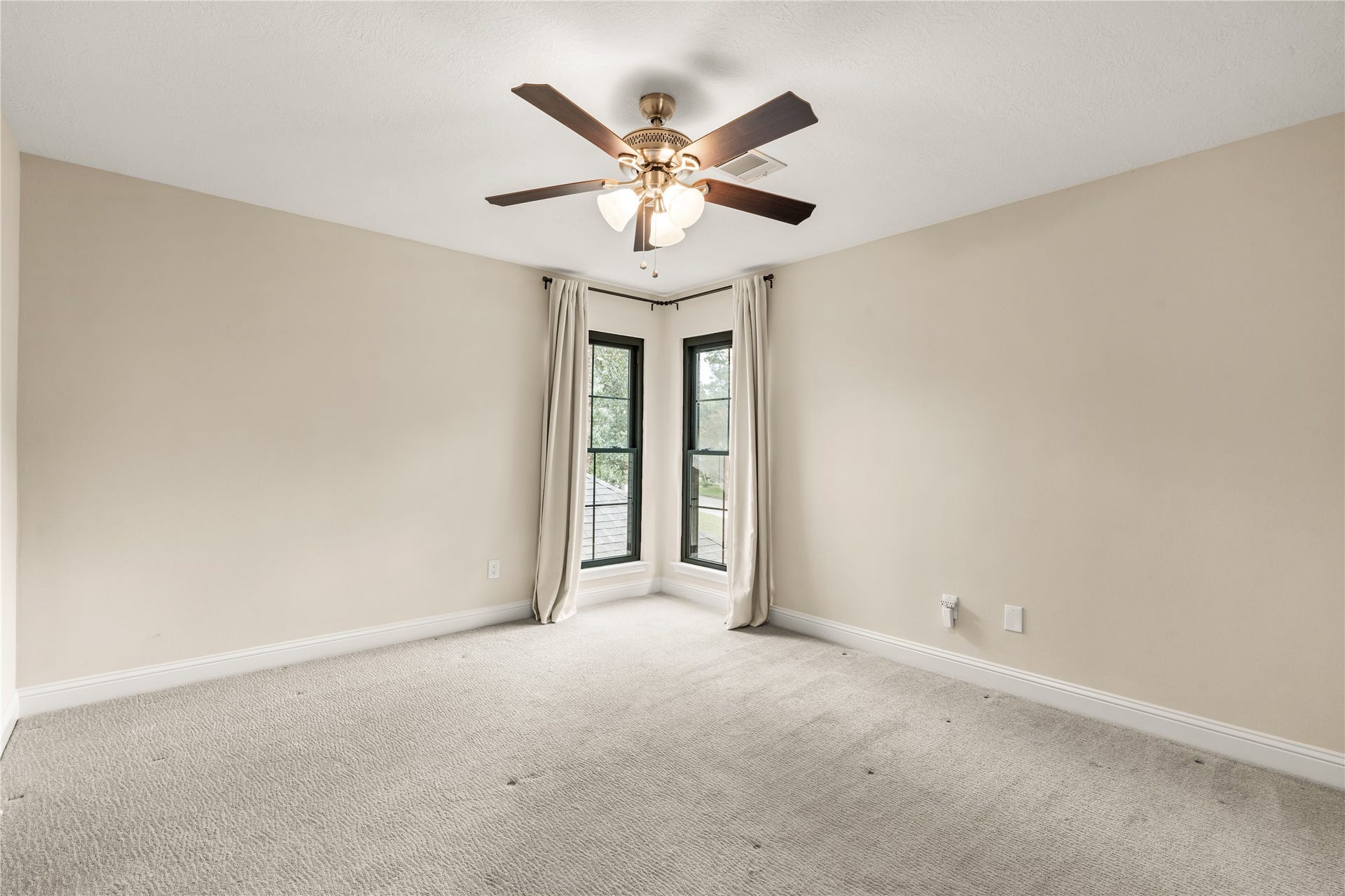 4719 Breezy Point Drive, Houston, TX 77345 This generously sized secondary bedroom is filled with natural light from corner windows and offers ample flexibility for guests, family, or a private retreat.