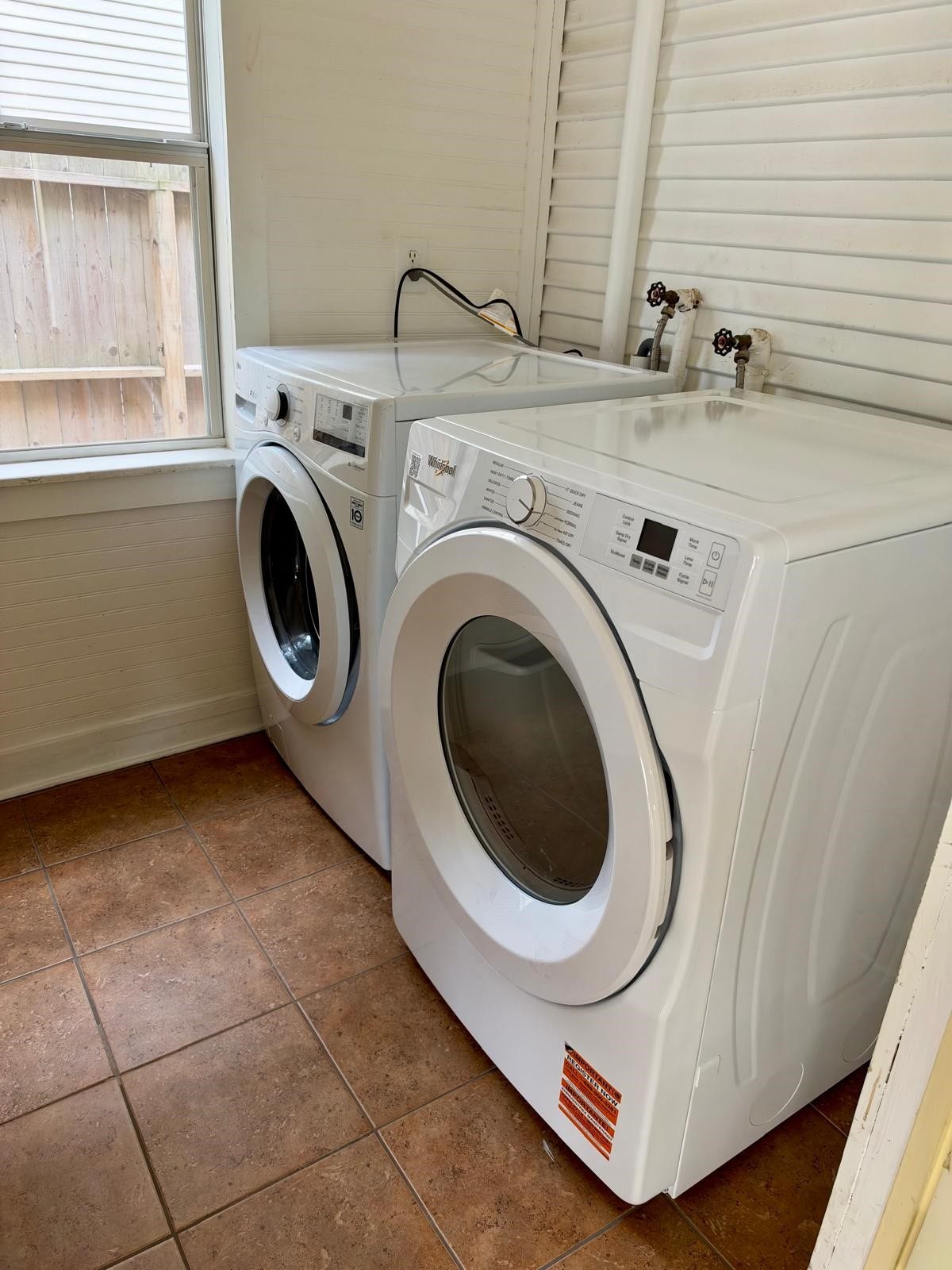 Laundry room includes full-size washer and dryer folding table and hanging space