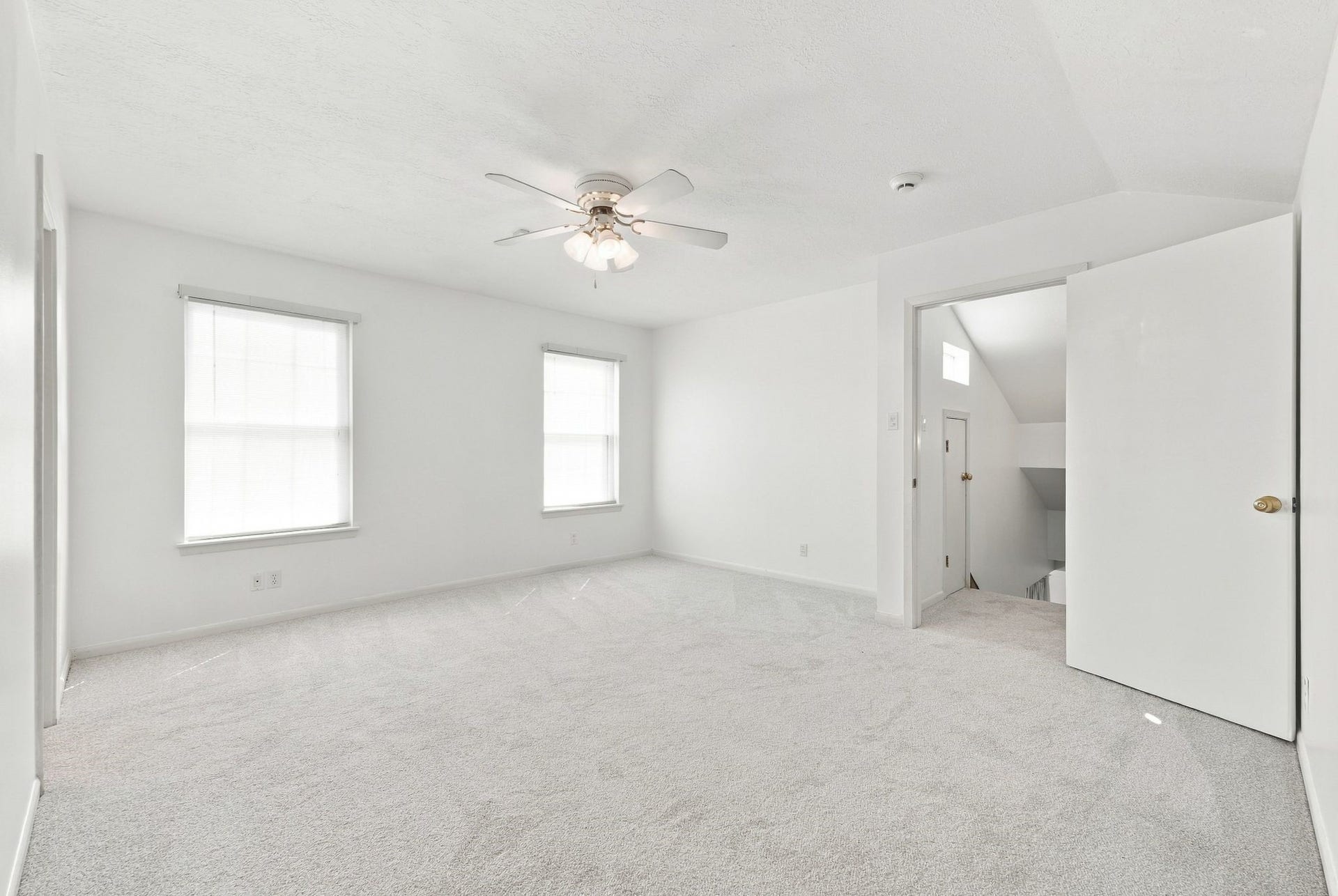 5125 Nina Lee Lane, Houston, TX 77092 Convenient laundry nook with modern washer and dryer, neatly tucked behind wooden doors, complemented by overhead storage cabinets.