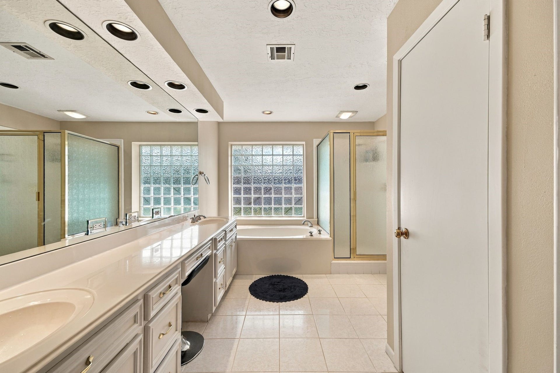 5125 Nina Lee Lane, Houston, TX 77092 Spacious bedroom with plush carpeting, a ceiling fan, and natural light flowing through a large window.