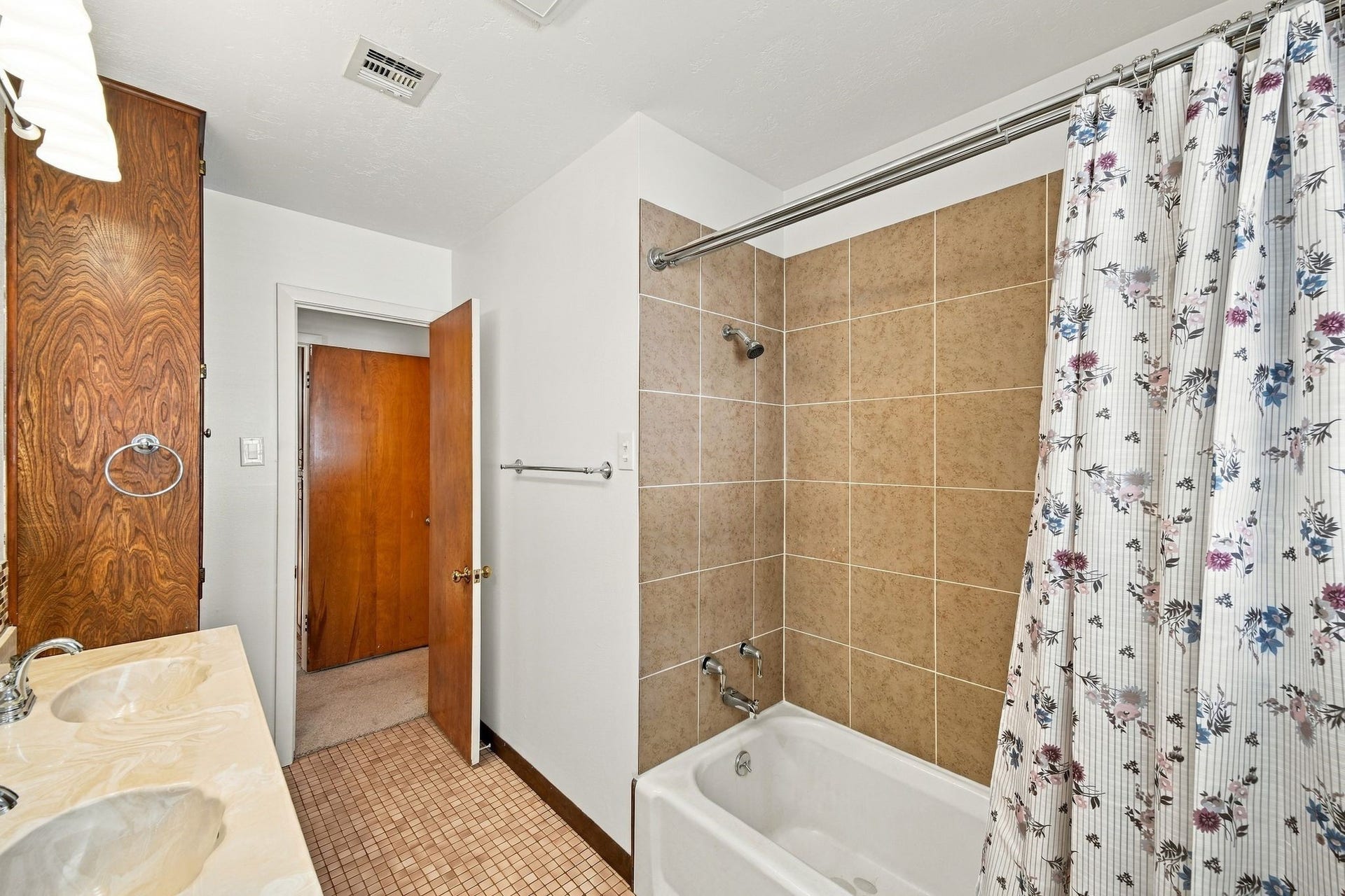 5125 Nina Lee Lane, Houston, TX 77092 Bright bathroom with dual sinks, elegant tile backsplash, and a cozy shower-tub combo.