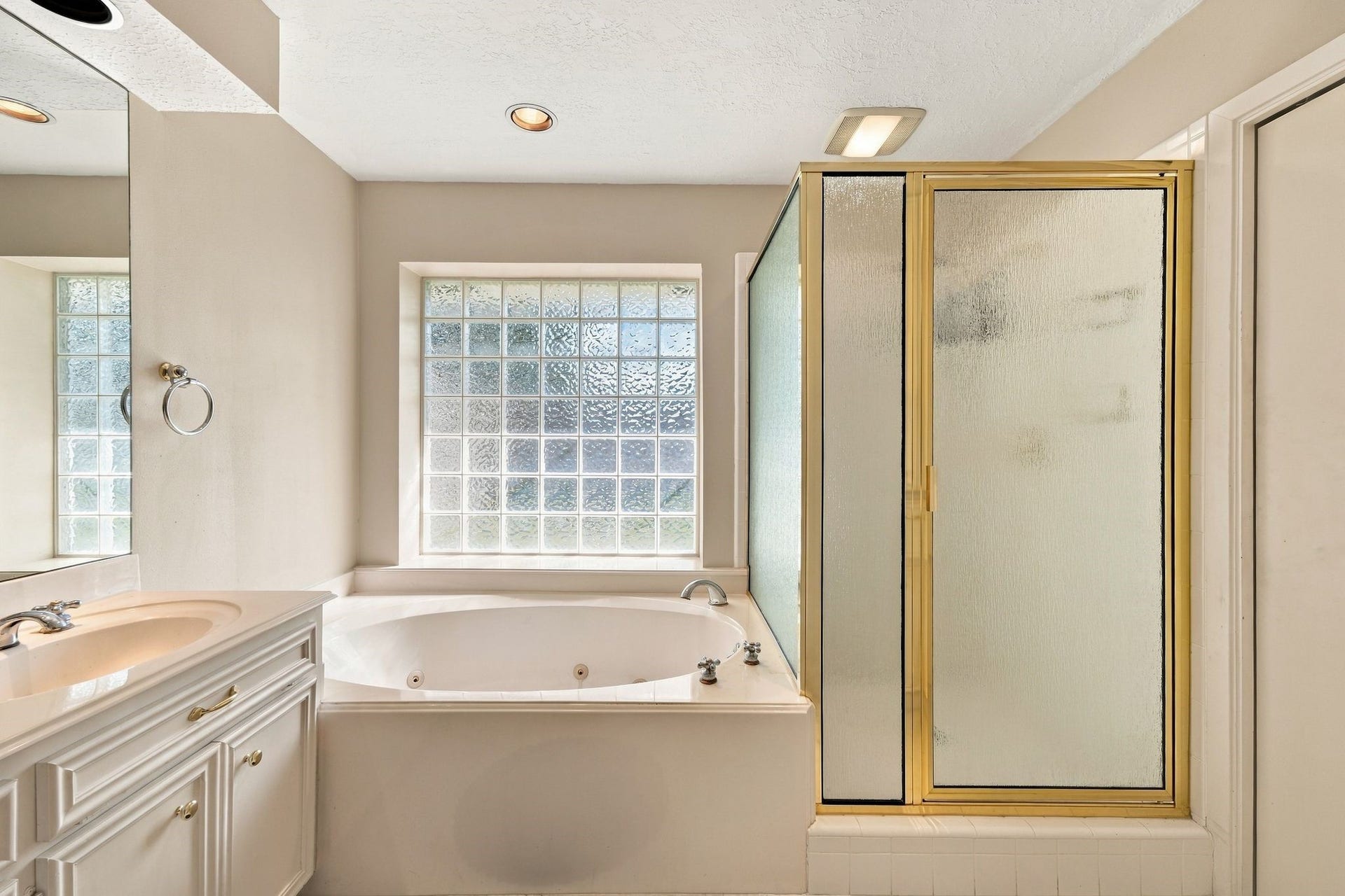 5125 Nina Lee Lane, Houston, TX 77092 Expansive bathroom with a dual-sink vanity, generous cabinetry, and a full-length mirror, seamlessly adjoining a cozy bedroom.