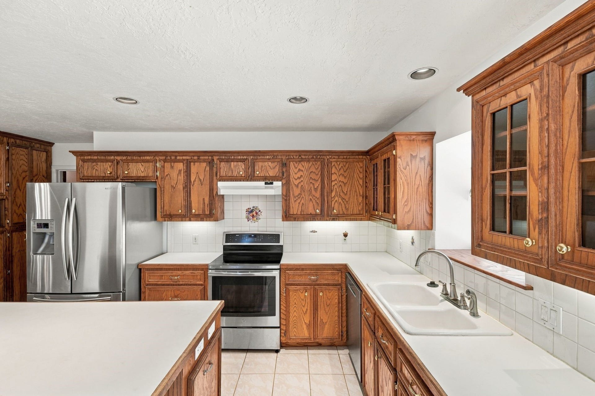 5125 Nina Lee Lane, Houston, TX 77092 Chefs' kitchen featuring rich wooden cabinetry, a central island with seating, modern stainless steel appliances, and ample counter space for cooking and entertaining.