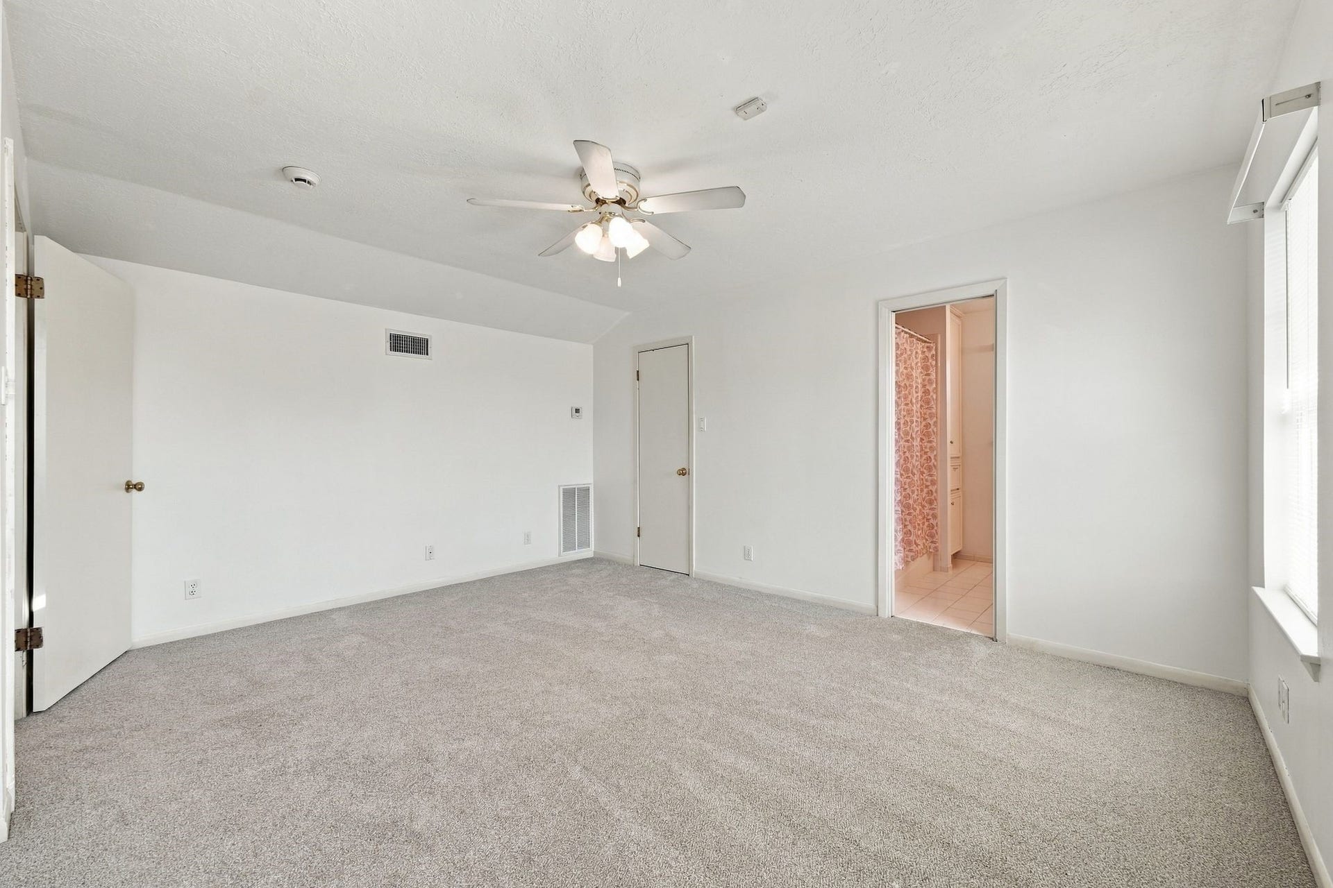 5125 Nina Lee Lane, Houston, TX 77092 Spacious living area featuring a cozy brick fireplace, plush carpeting, and a stylish staircase leading to the upper level.
