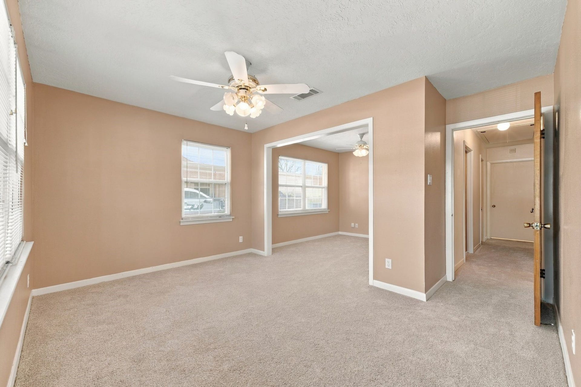 5125 Nina Lee Lane, Houston, TX 77092 Expansive bedroom bathed in natural light, featuring plush carpeting and mirrored closet doors for a touch of elegance.