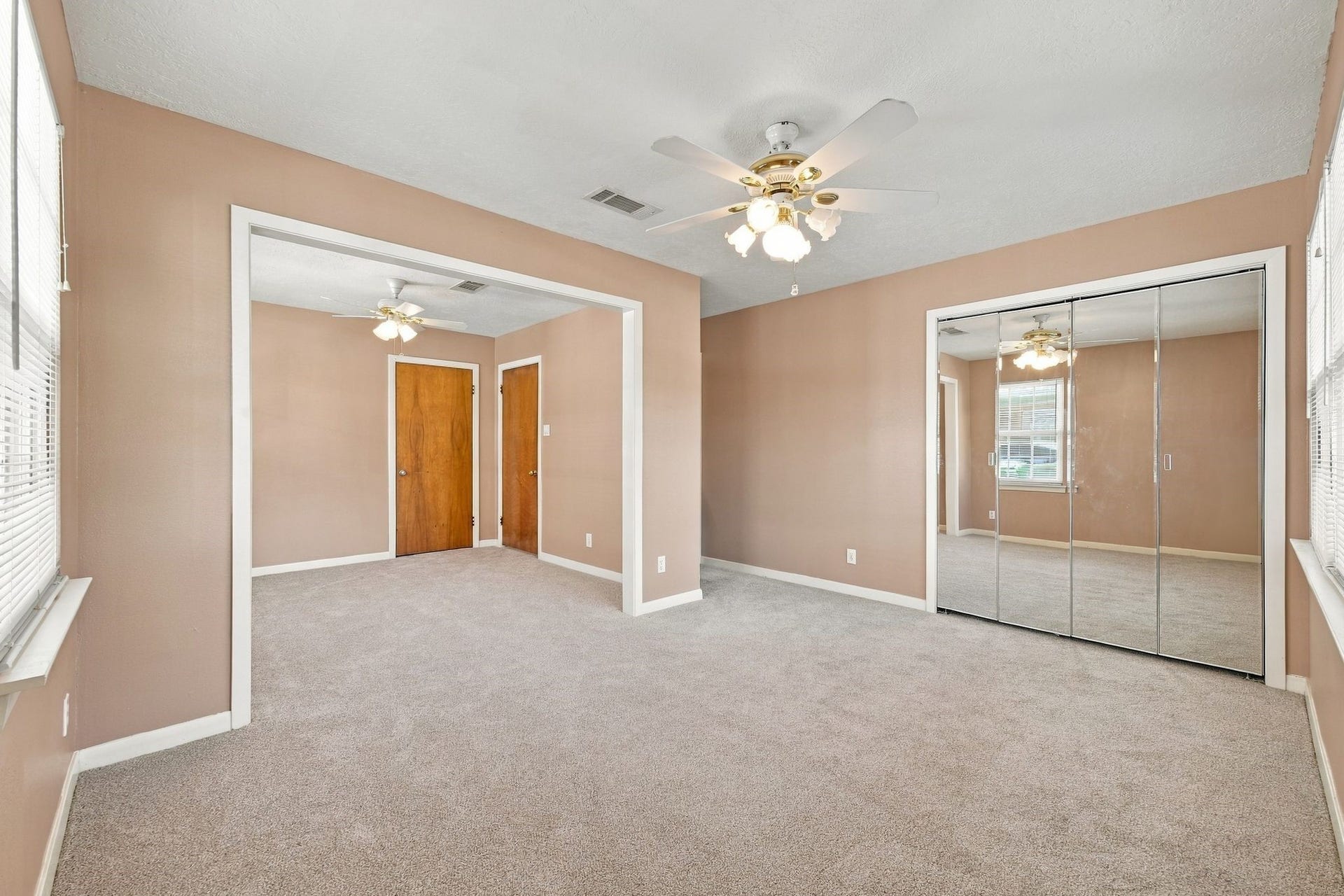 5125 Nina Lee Lane, Houston, TX 77092 Bright and inviting living space featuring large windows, plush carpeting, and dual ceiling fans for comfort.