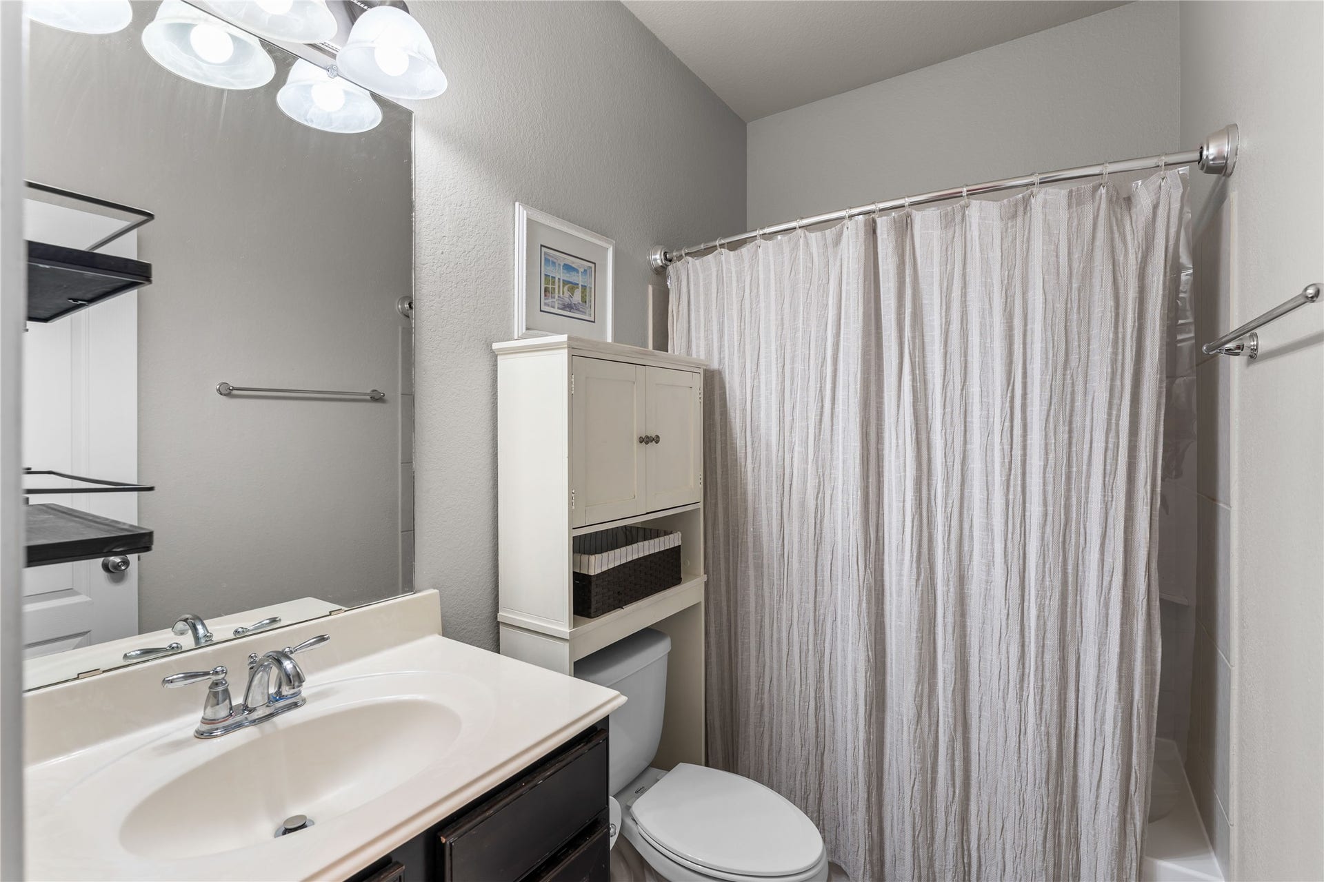 Full secondary bathroom with vanity and tub/shower combination.