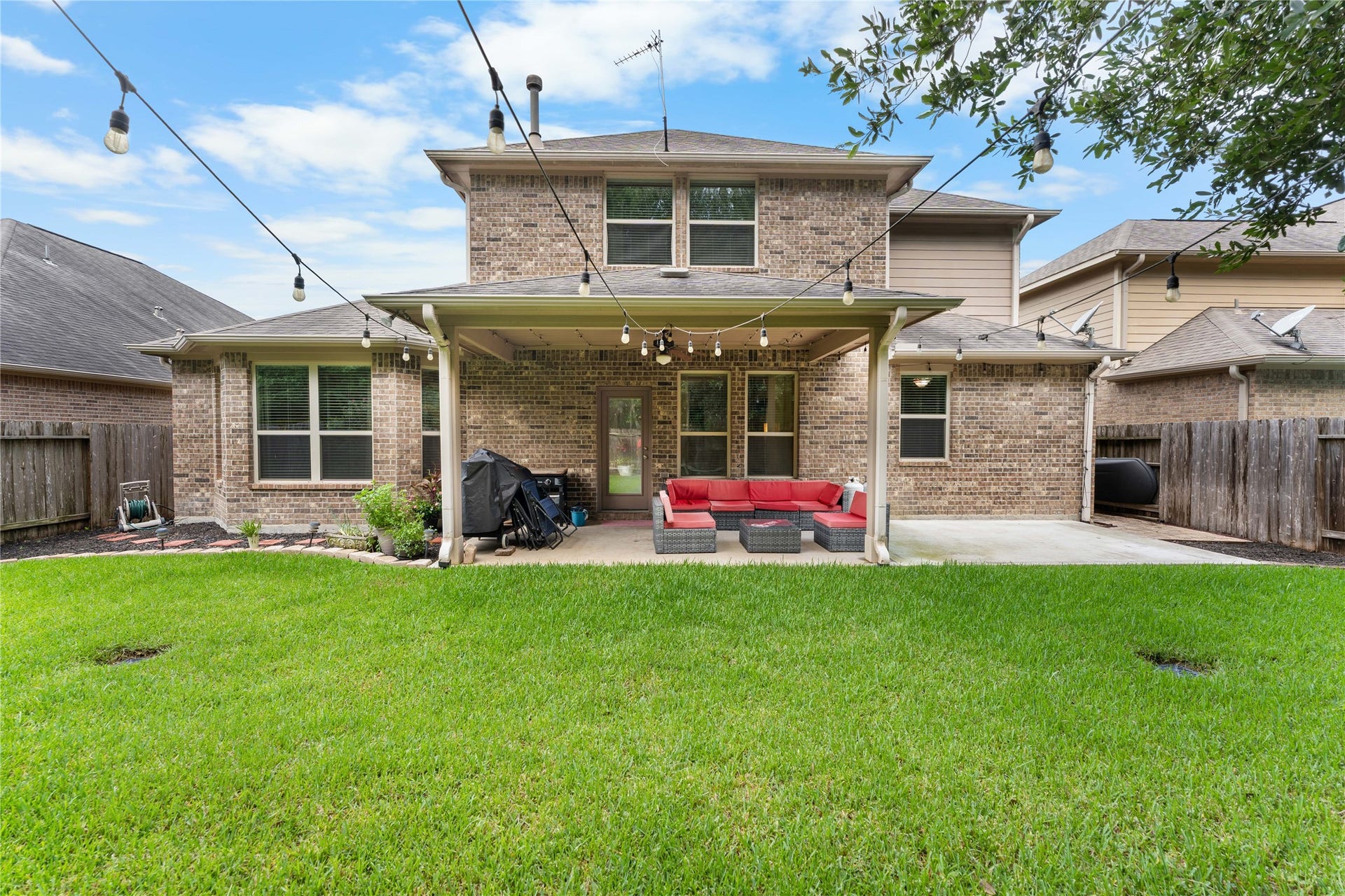 Covered back patio overlooking a fully fenced backyard with room to enjoy the outdoors.