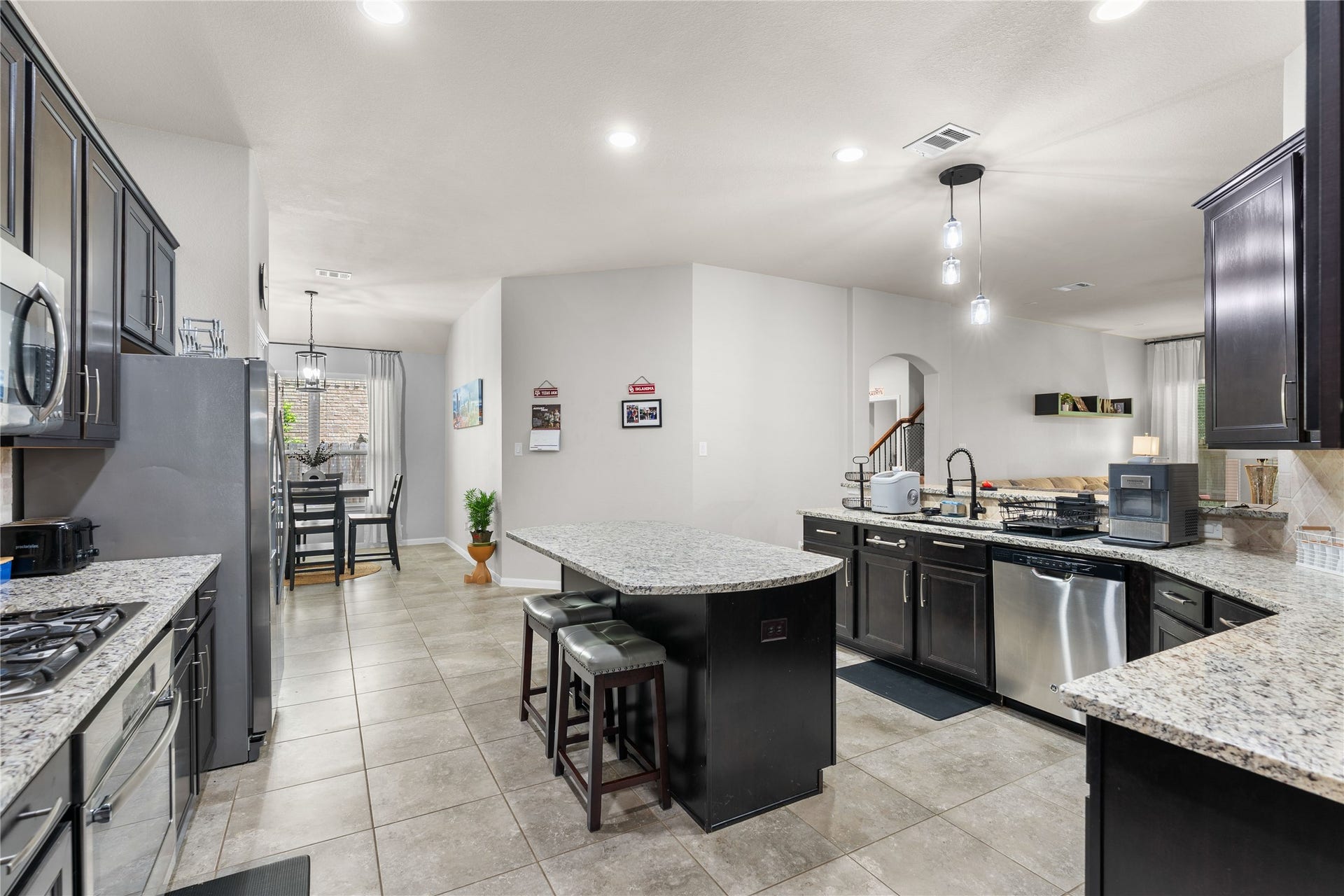 Open-concept kitchen featuring granite countertops, generous prep space, and bar seating.