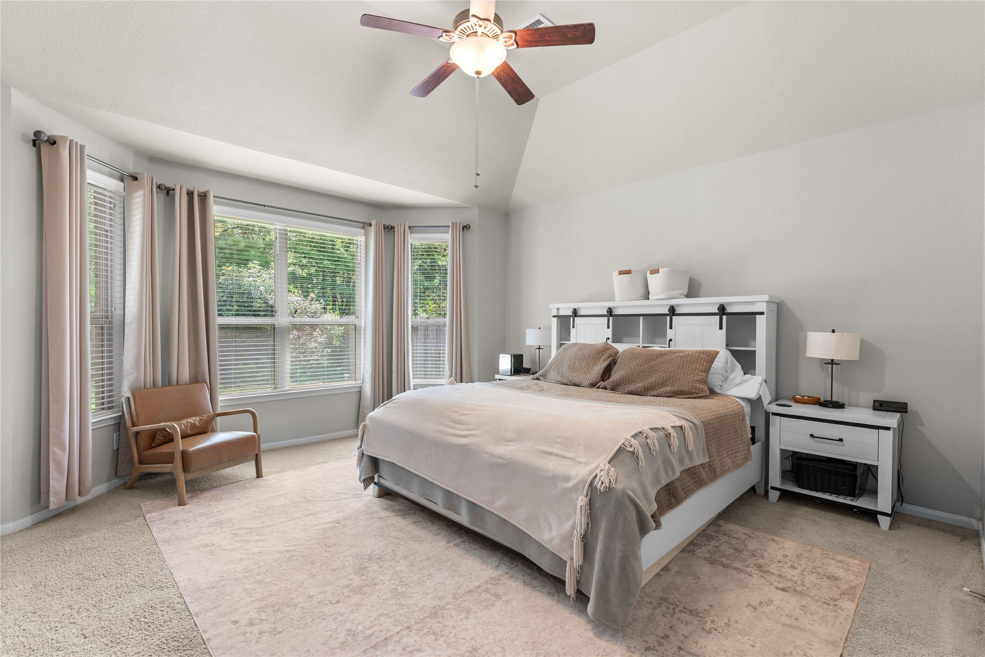 Spacious primary bedroom with large windows and a relaxing atmosphere.