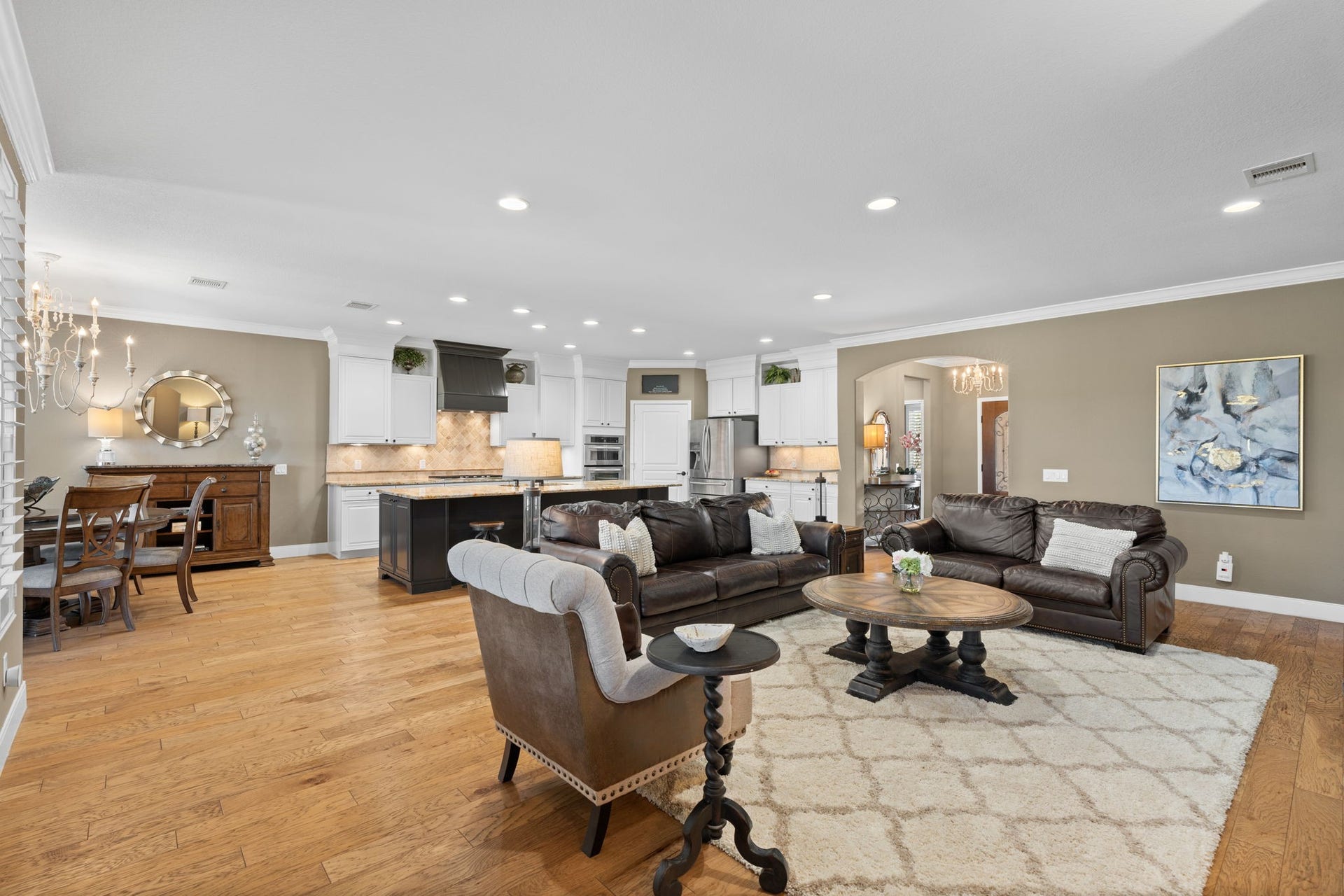 Beautiful wood flooring graces this exquisite home. As you step into this inviting space, you'll notice the seamless flow from the gathering area, through the dining room, and into the kitchen.