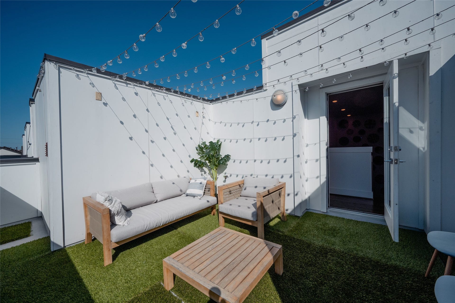 2826 Clay Street, Houston, TX 77003 Experience outdoor relaxation on this charming rooftop terrace featuring cozy seating, string lights, and lush artificial grass, perfect for entertaining or unwinding under the stars.