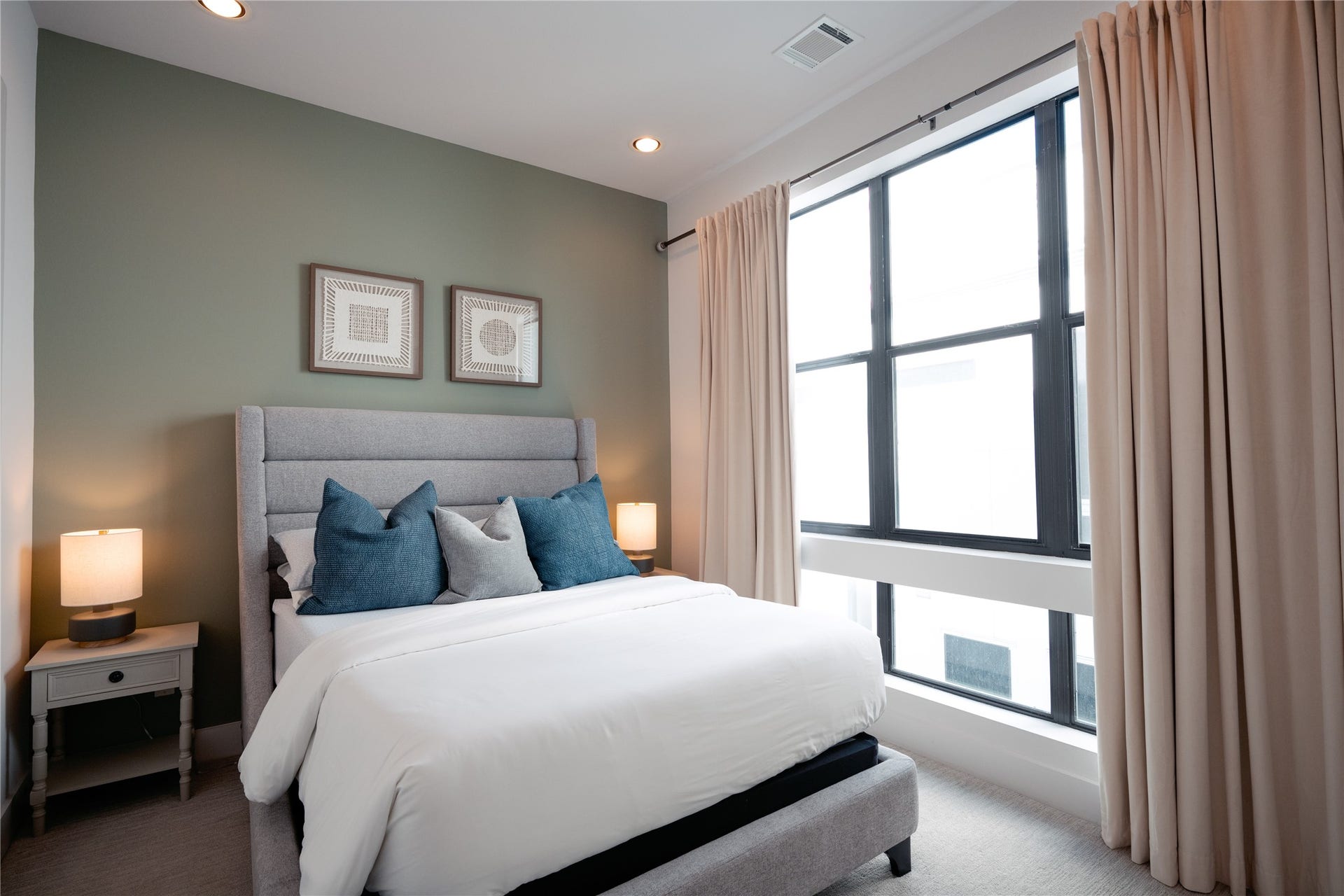 2826 Clay Street, Houston, TX 77003 Cozy bedroom featuring a stylish upholstered bed, soft lighting, and large windows with elegant drapes for natural light.