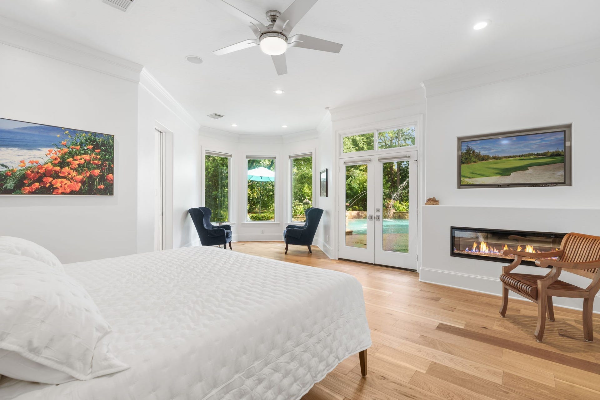 39 N Palmiera Circle, The Woodlands, TX 77382 An inviting and relaxing primary suite with newly designed wall space (removed dated built-in cabinetry) adding a clean lined electric fireplace, and recessed wall above for TV mounting. Above, a new modern ceiling fan.