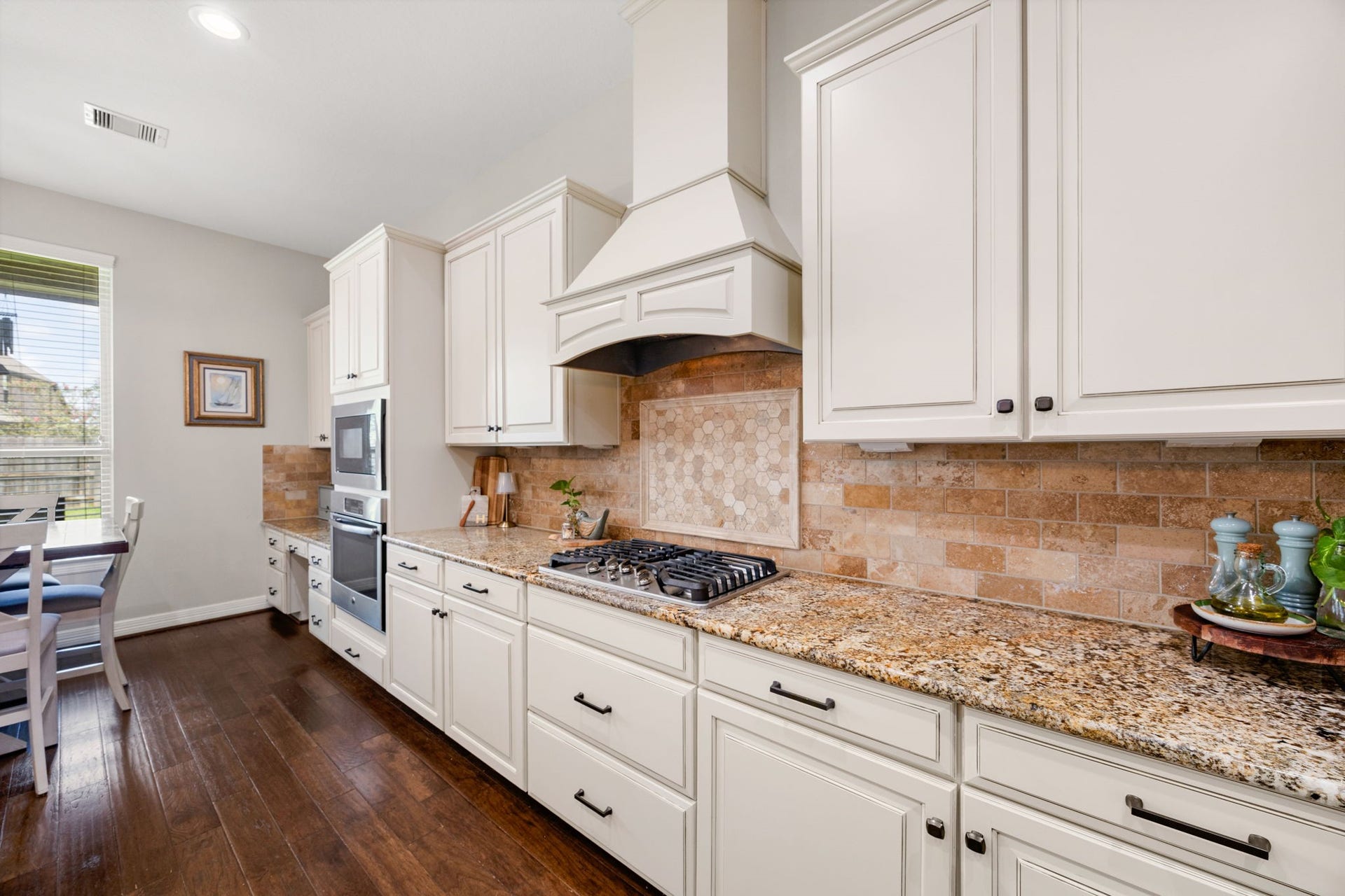 13522 Columbia Key Drive, Tomball, TX 77377 From this angle, the kitchens stone backsplash, cooktop, and surrounding counter space come into focus, highlighting both style and everyday function.