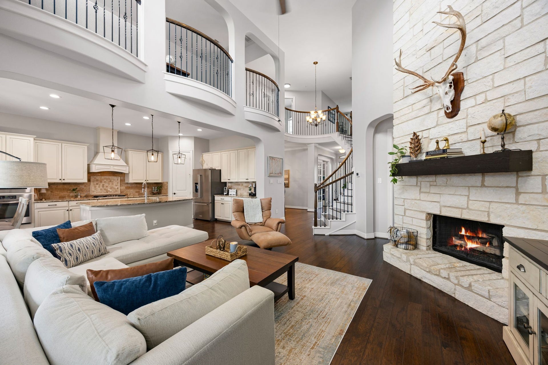 13522 Columbia Key Drive, Tomball, TX 77377 From this angle, the living rooms open connection to the kitchen and upstairs landing comes into view, with iron and dark wood banisters adding to the homes architectural detail.