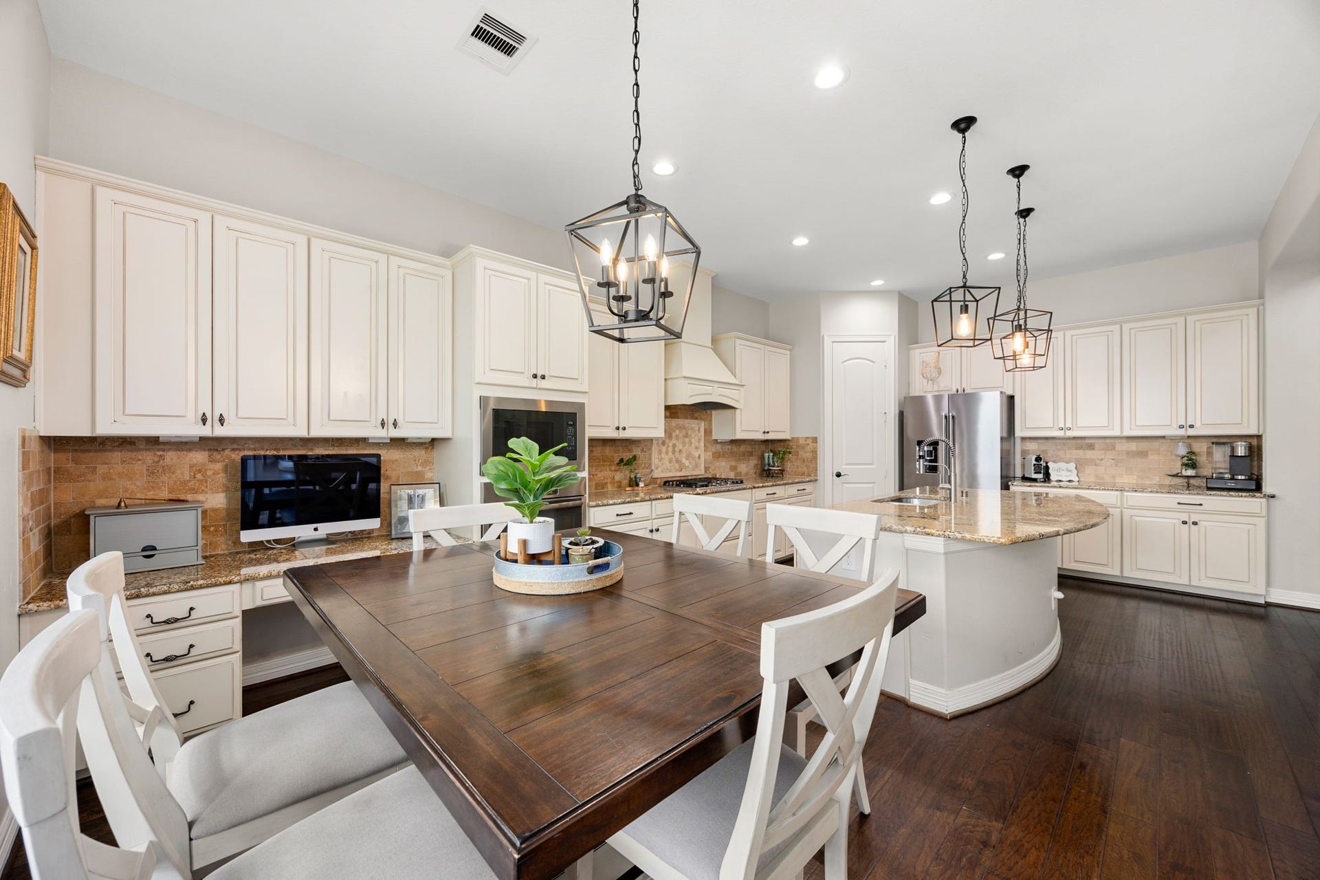 13522 Columbia Key Drive, Tomball, TX 77377 From this angle, the kitchen showcases its spacious island with seating, cream cabinetry, striking stone backsplash, and bright breakfast area - all opening naturally to the living room for easy everyday living and entertaining.