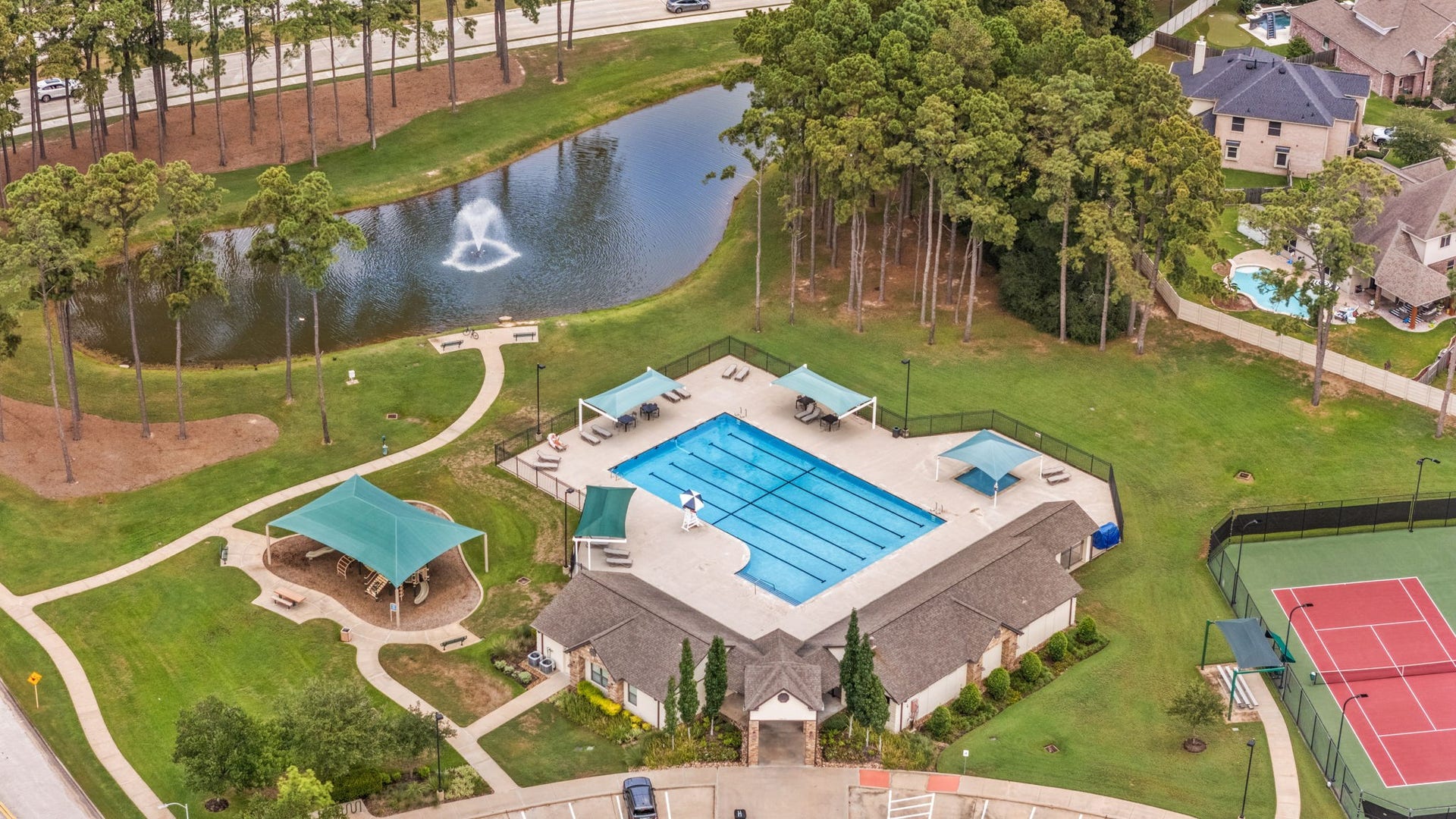 13522 Columbia Key Drive, Tomball, TX 77377 A closer aerial perspective highlights the pool area, covered playground, and tennis courts, offering a clear look at the neighborhoods recreation spaces.