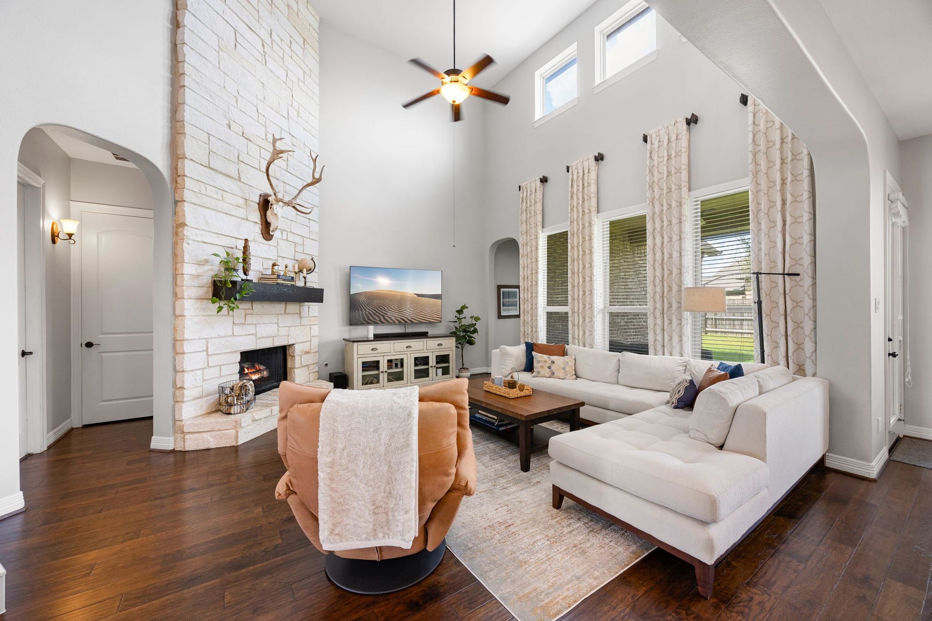 13522 Columbia Key Drive, Tomball, TX 77377 Soaring ceilings, a dramatic floor-to-ceiling stone fireplace, and a wall of windows overlooking the backyard fill the living room with natural light and warmth.