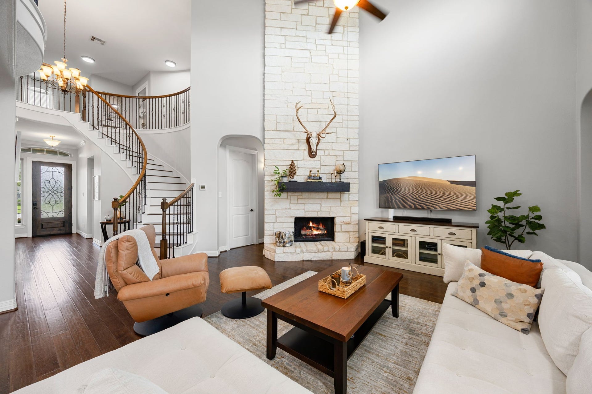 13522 Columbia Key Drive, Tomball, TX 77377 This angle highlights the living rooms striking floor-to-ceiling stone fireplace and sweeping staircase, while also offering a glimpse of the front entry and the homes grand, open feel.